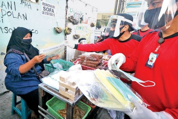 Satgas Kampung Tangguh membagikan pelindung wajah (face shield) kepada pedagang di Pasar Keputih, Surabaya, Jawa Timur, kemarin.