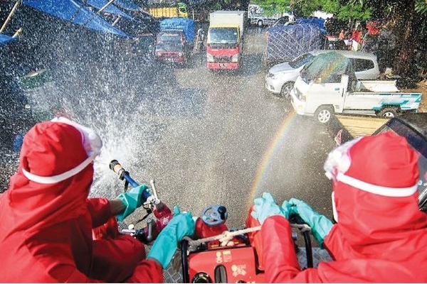 Petugas pemadam kebakaran melakukan penyemprotan disinfektan di Pasar Induk Kramat Jati, Jakarta Timur, kemarin.