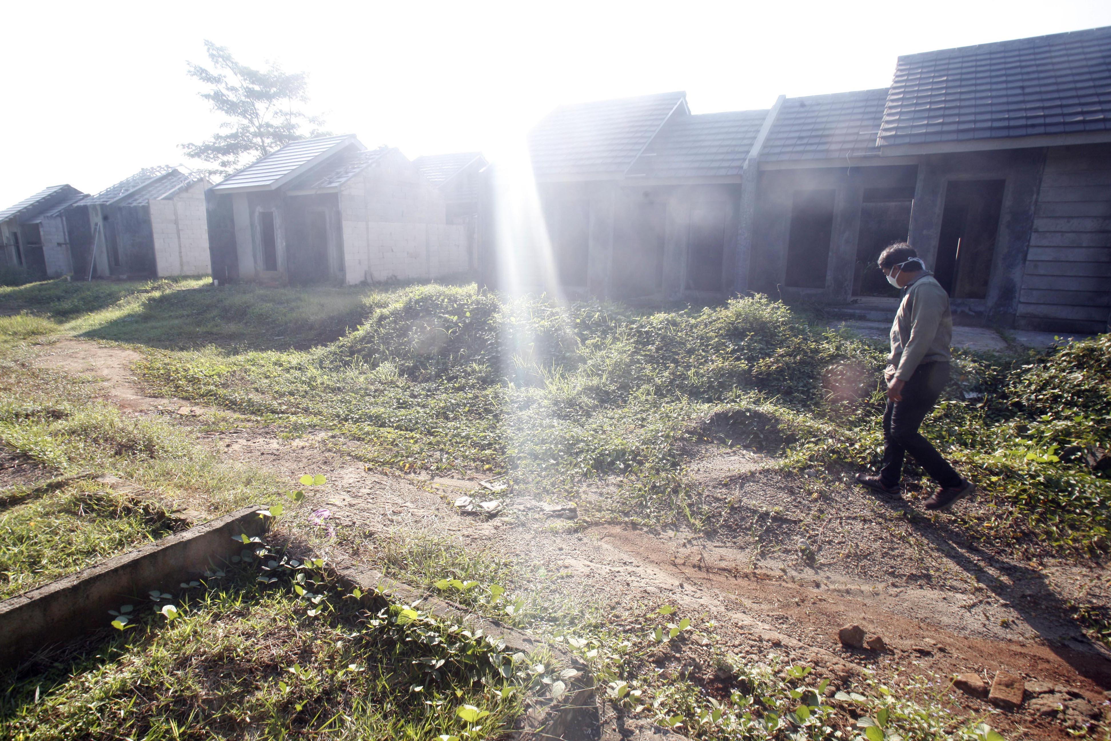 Warga melintas di depan rumah bersubsidi yang sedang dibangun, di Bojong Gede, Kabupaten Bogor, Jawa Barat, Selasa (12/5). 