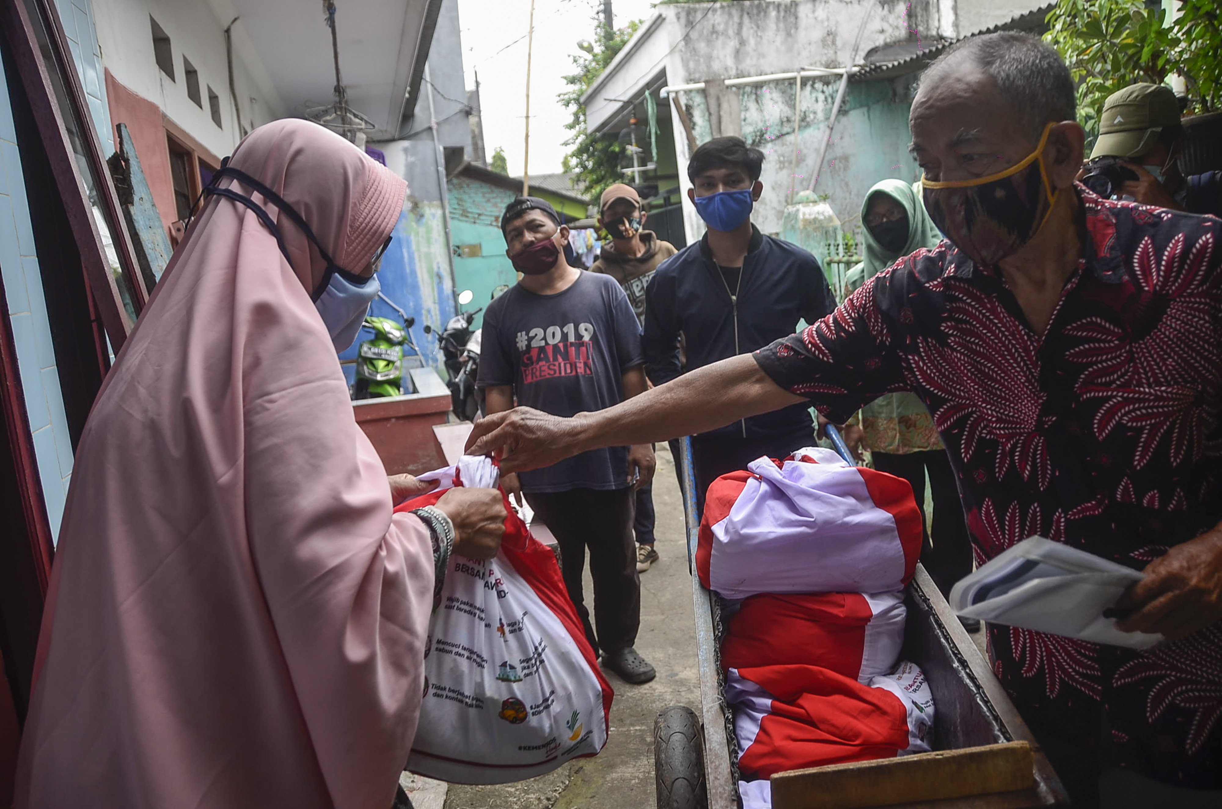 etugas membawa bantuan sembako untuk dibagikan kepada warga di daerah Kayuringin, Bekasi, Jawa Barat, Sabtu (9/5). 