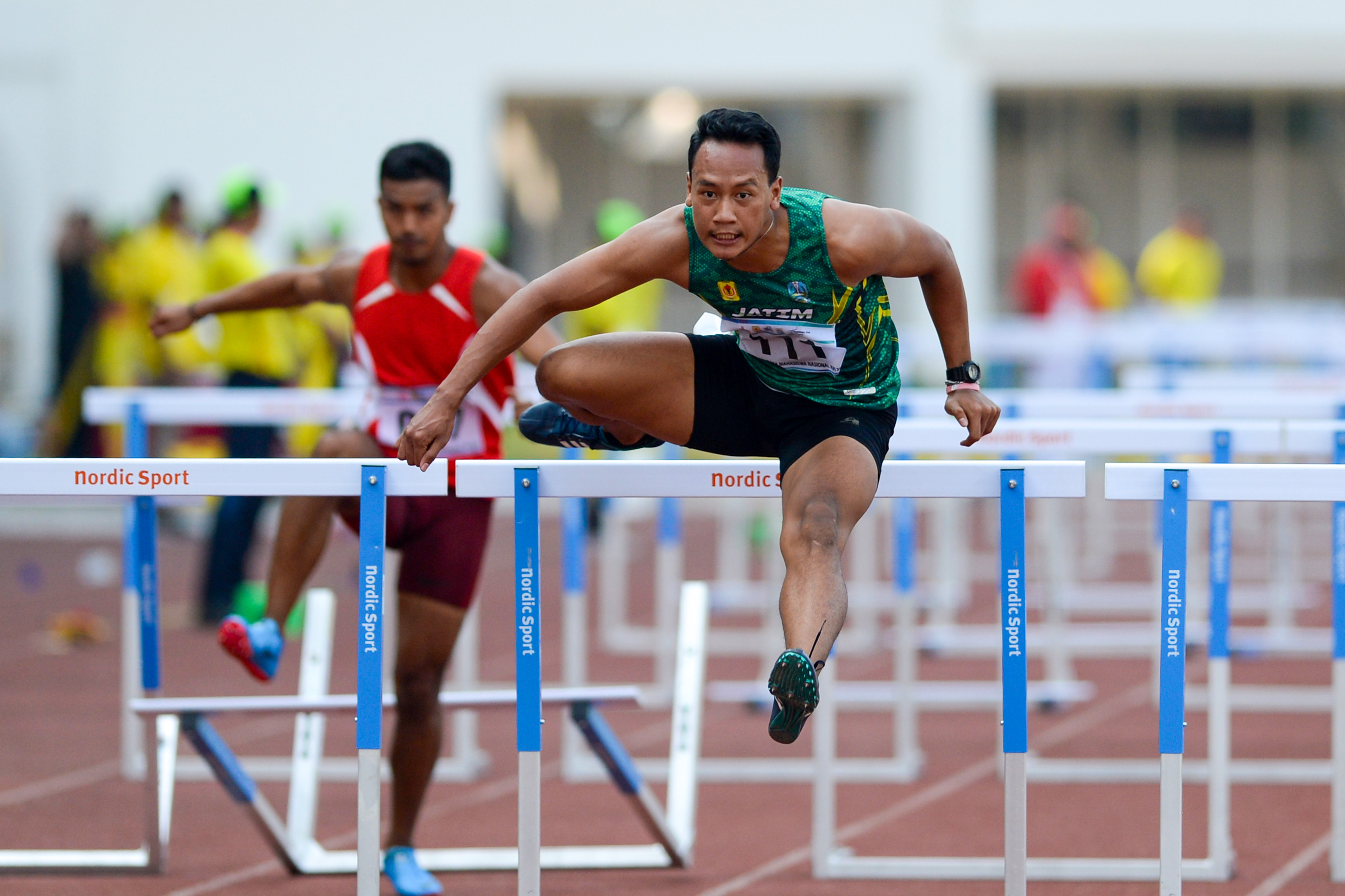 Pelari asal Jawa Timur, Ghanes Bagus Pandega, melompati rintangan dalam final POMNAS XVI di Stadion Madya.
