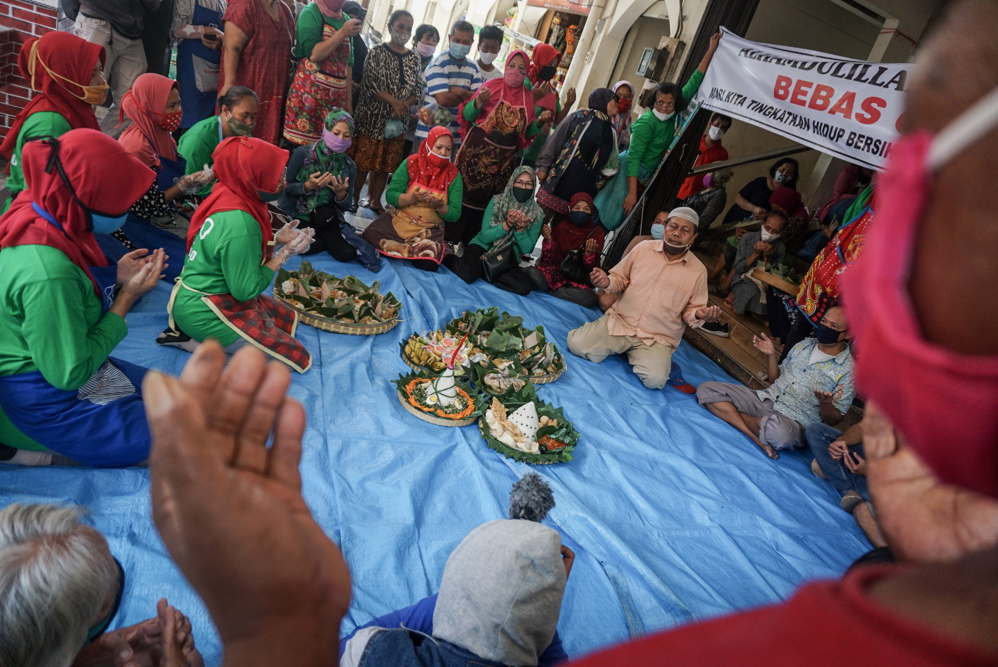 Pedagang dengan membawa nasi tumpeng memanjatkan doa saat Syukuran Pedagang di Pasar Kadipolo, Solo, Jawa Tengah, Rabu (10/6), kemarin.