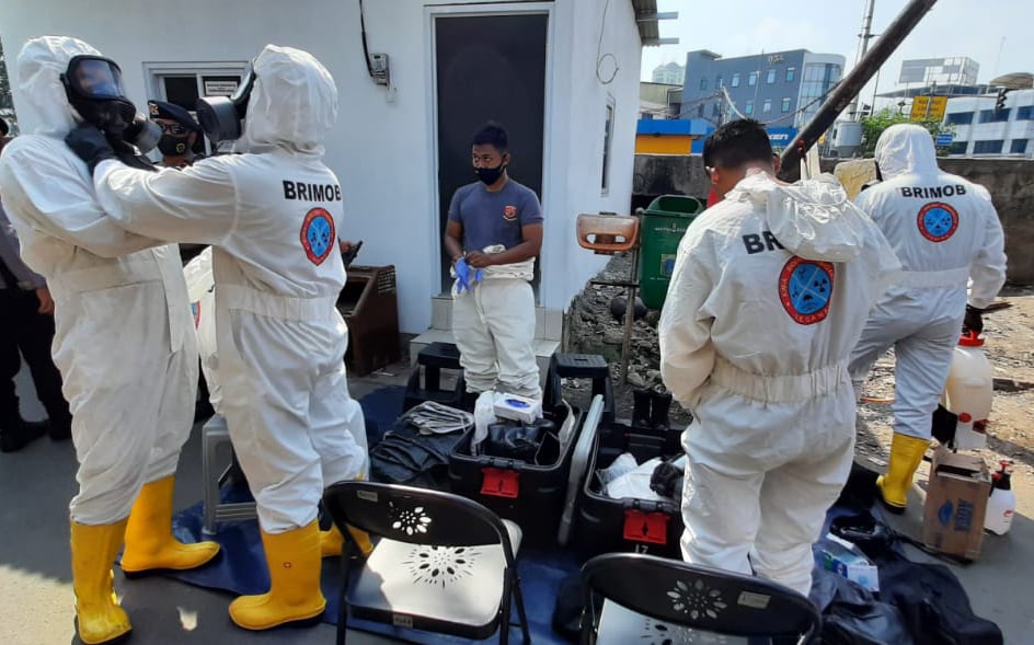 Para personel Brimob bersiap mengenakan pakaian Hazmat saat akan melakukan penyemprotan disinfektan di Kelurahan Sawah Besar, Jakarta Pusat,