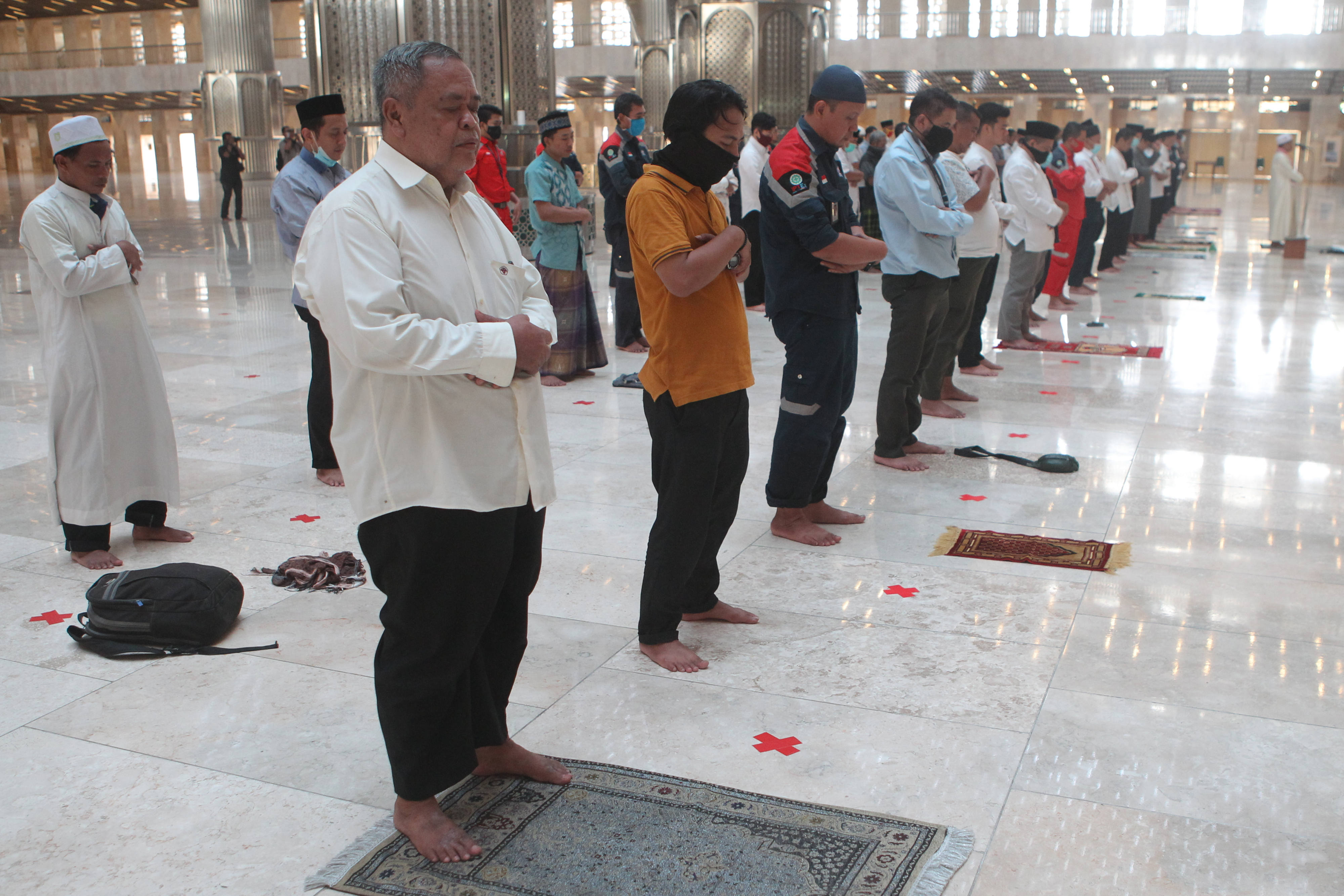 Pekerja renovasi dan pengurus Masjid Istiqlal menunaikan ibadah sholat Dzuhur dengan penerapan prosedur kenormalan baru. 