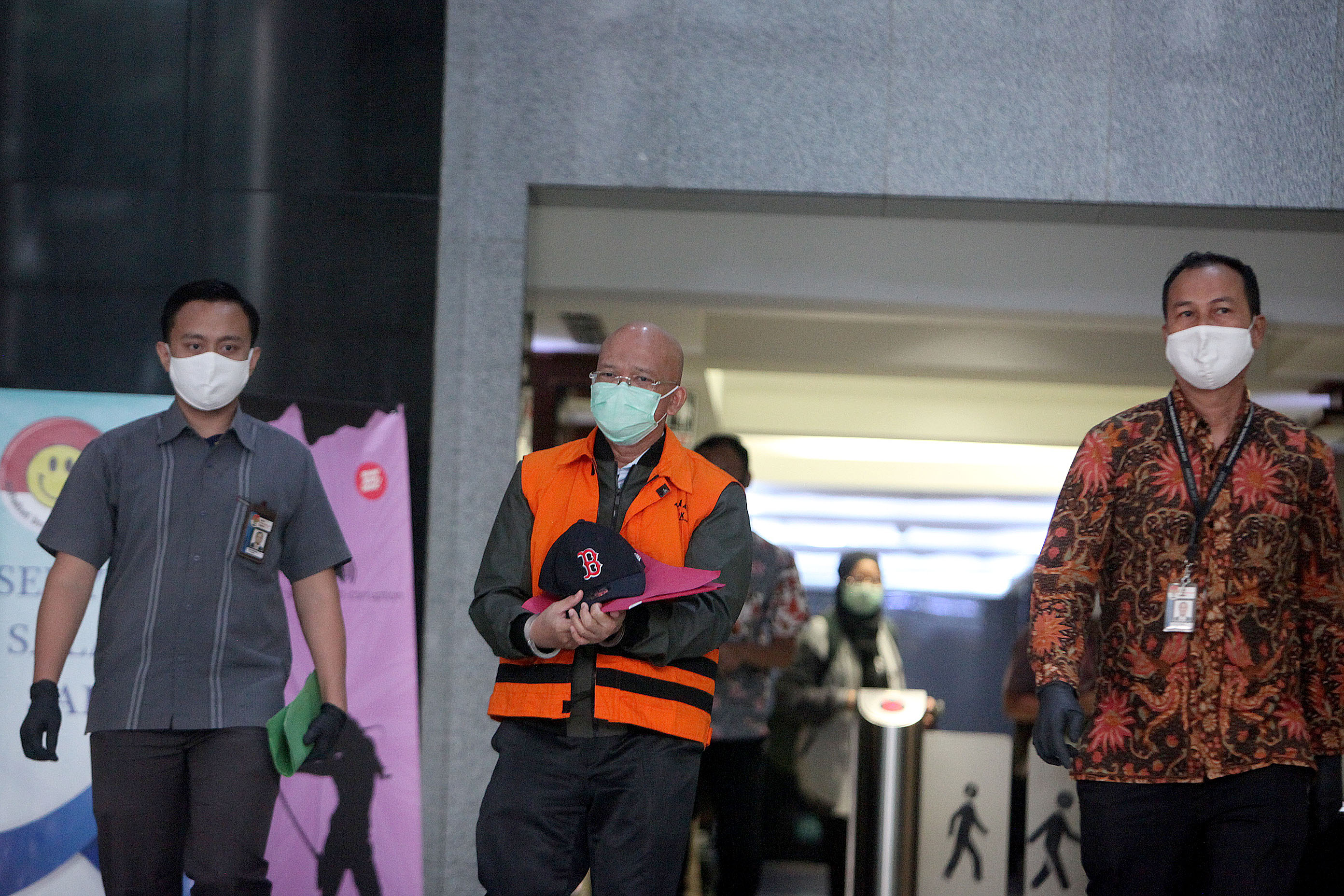 Direktur PT Humpuss Transportasi Kimia (HTK) Taufik Agustono mengenakan rompi oranye berjalan keluar seusai menjalani pemeriksaan.