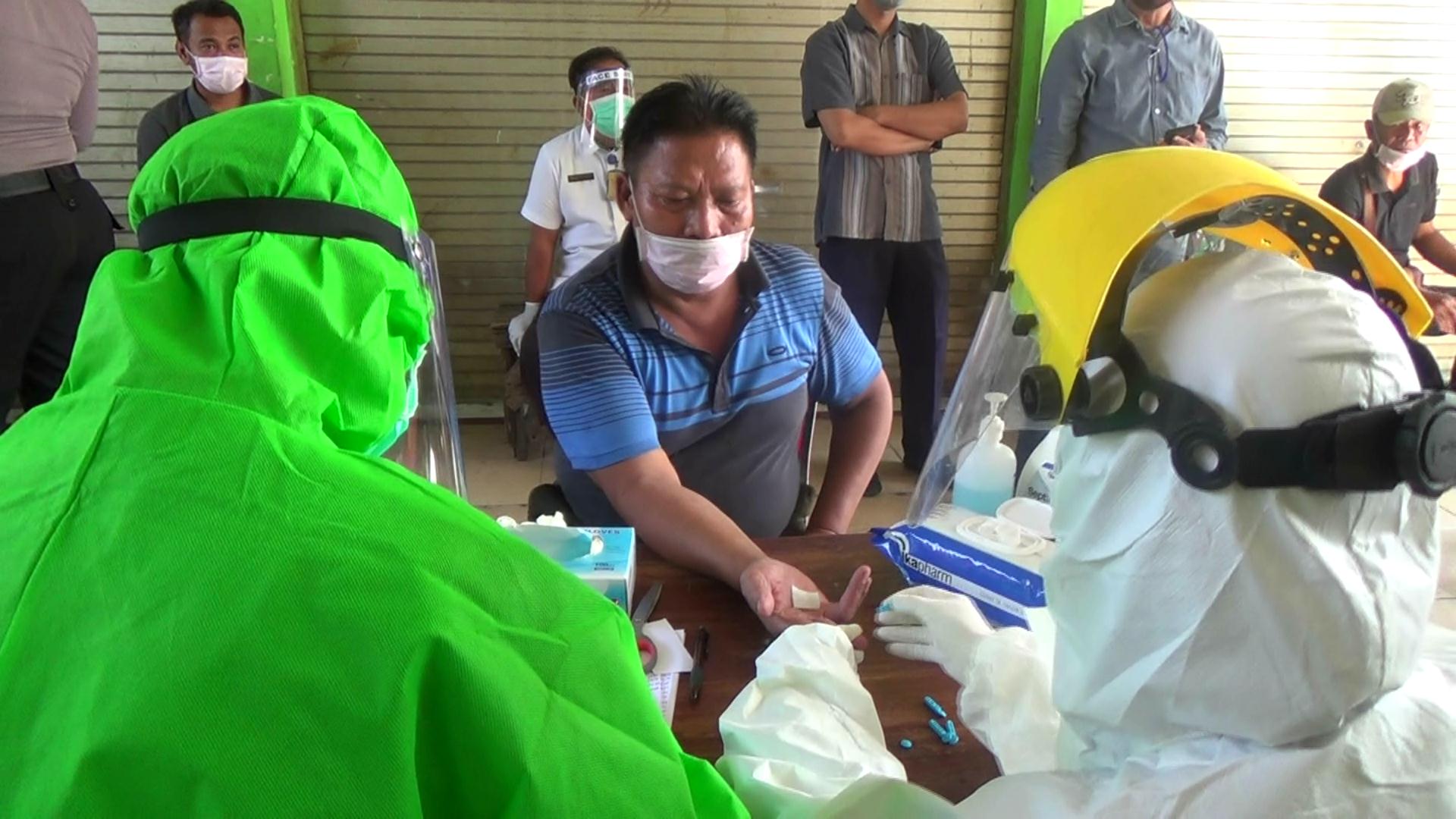 Seorang pedagang di Pasar Taman Kabupaten Sidoarjo, Jawa Timur, menjalani rapid test, Rabu (3/6). 