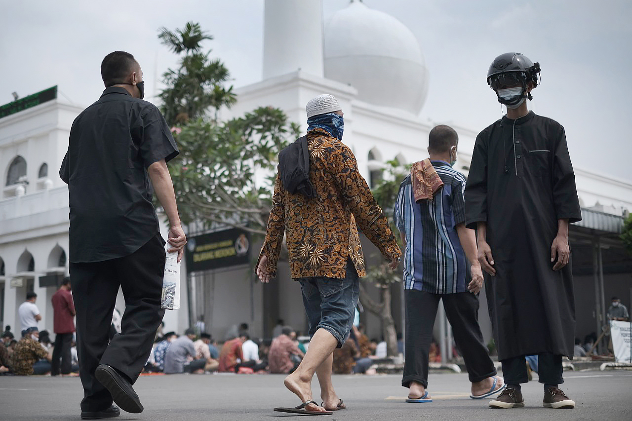  Pengurus Masjid Agung Al Azhar mengenakan helm pintar yang dapat memindai suhu tubuh jamaah yang akan beribadah salat Jumat 