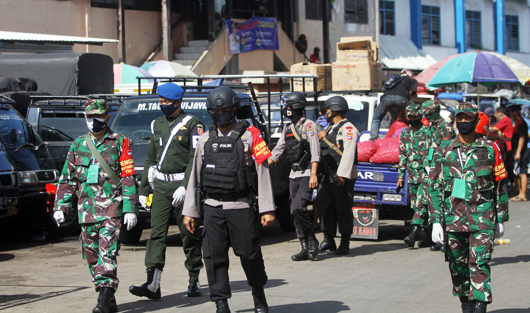Petugas TNI dan POLRI melakukan patroli serta menghimbau warga untuk mengikuti protokol kesehatan di Pasar Lima, Banjarmasin, Kalimantan.