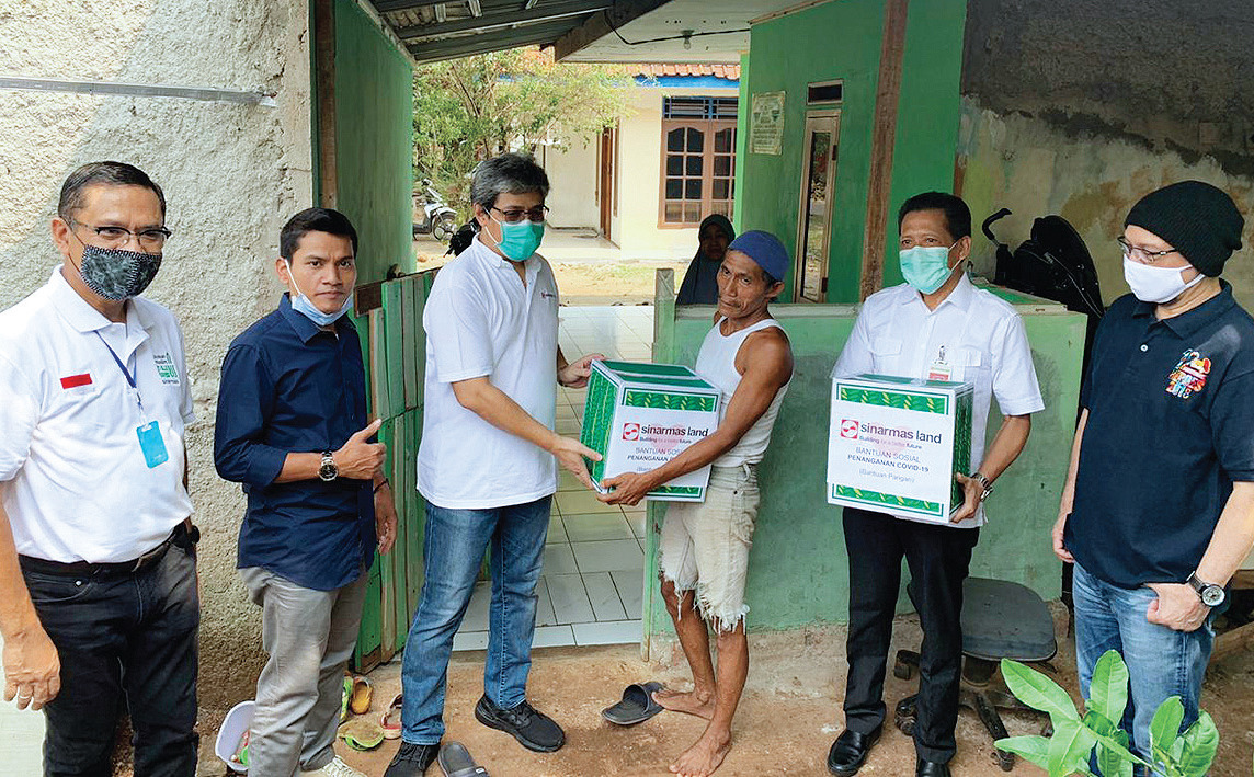 Managing Director President Office Sinar Mas Land Dhony Rahajoe (ketiga dari kiri) menyerahkan paket bantuan bahan pangan.