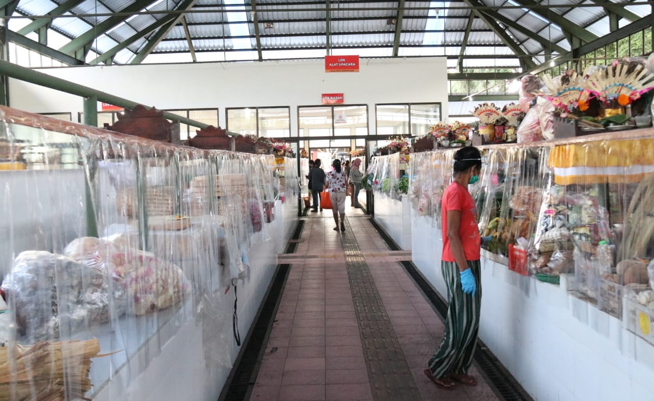Pemasangan plastik pembatas di pasar untuk meminimalkan kontak langsung pedadang dan pembeli.