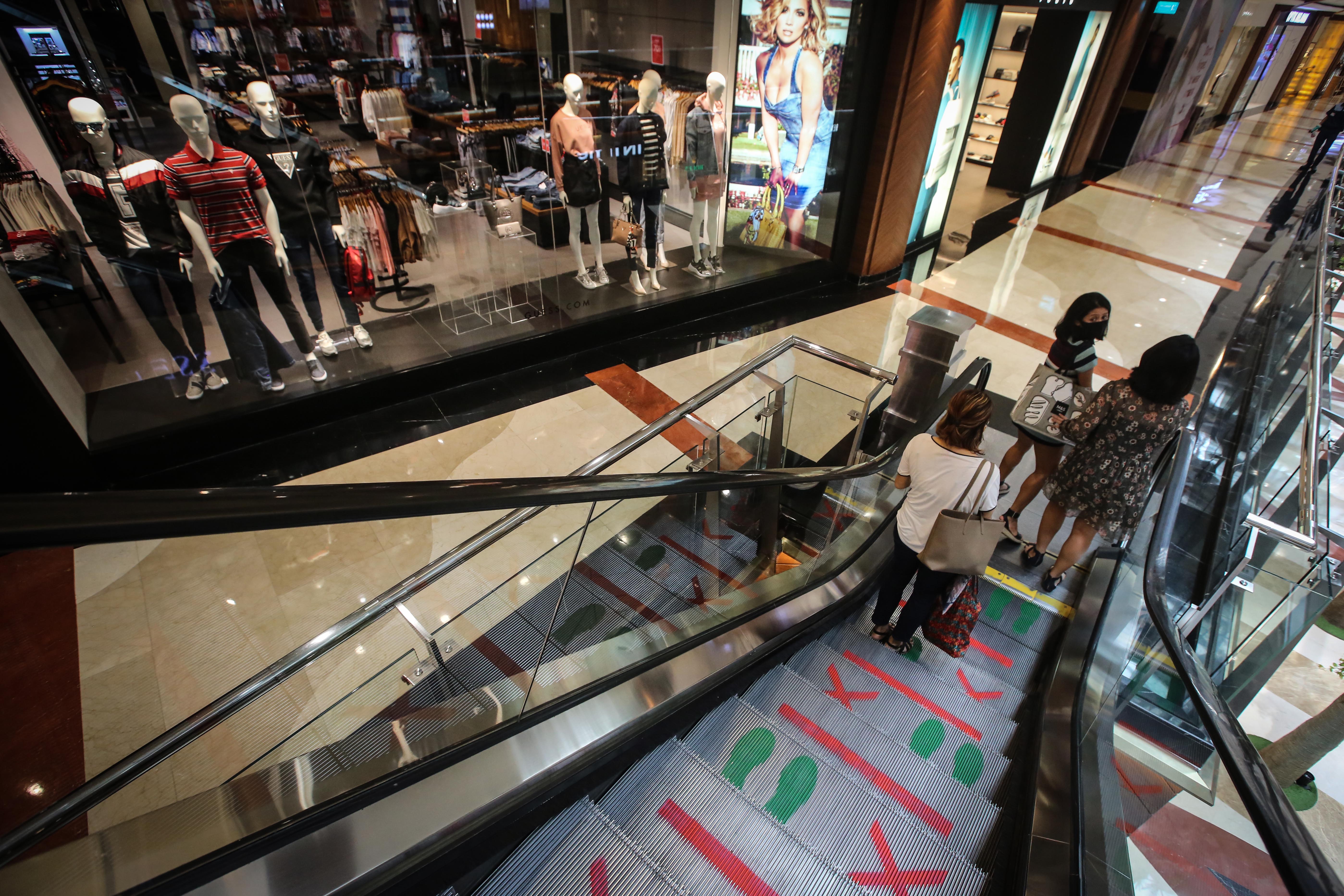 Pengunjung mal mengenakan masker saat berkunjung ke mal yang kembali dibuka di masa PSBB transisi