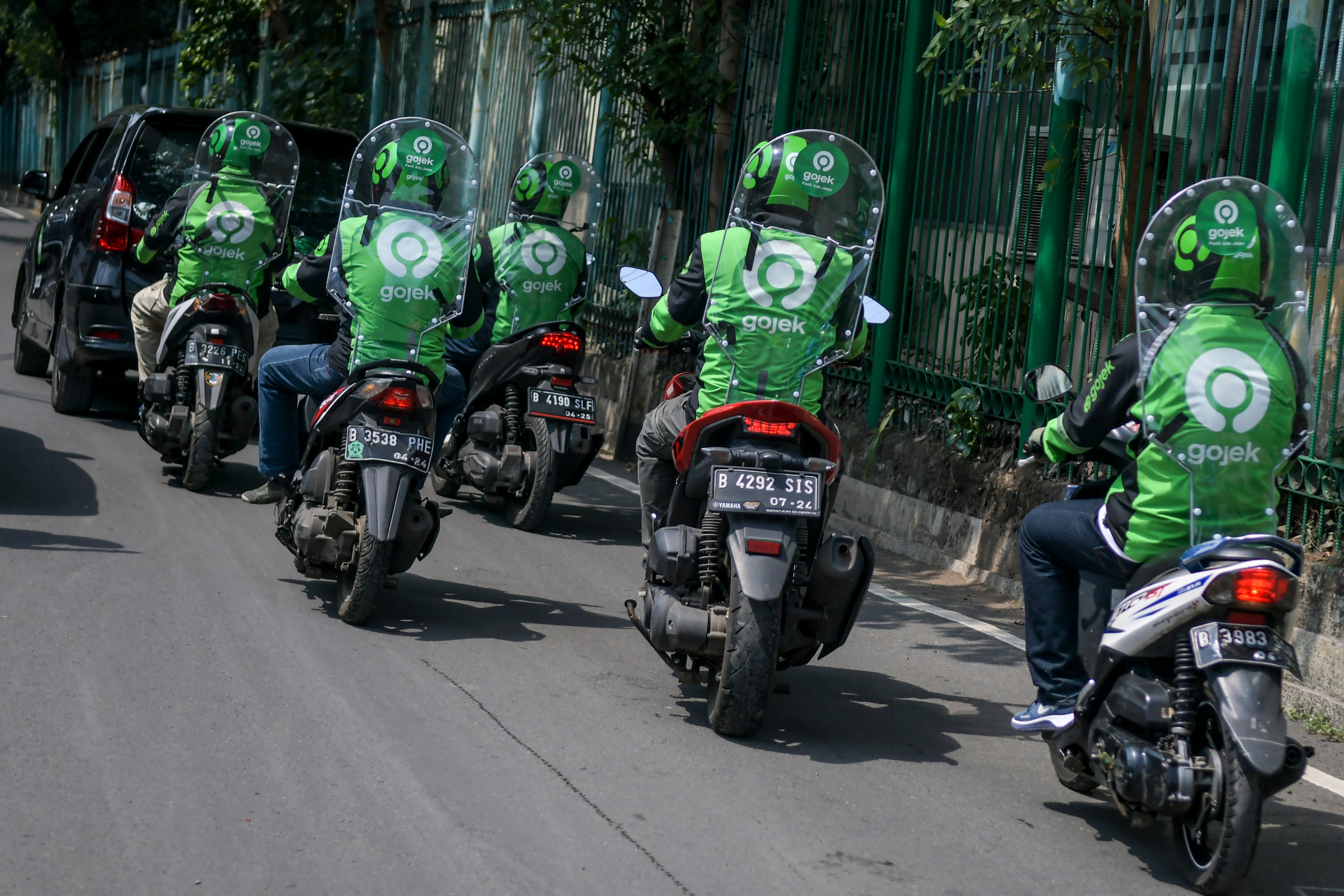  Pengemudi ojek daring mengenakan sekat pelindung saat melintas di kawasan jalan Kendal, Jakarta, Rabu (10/6).