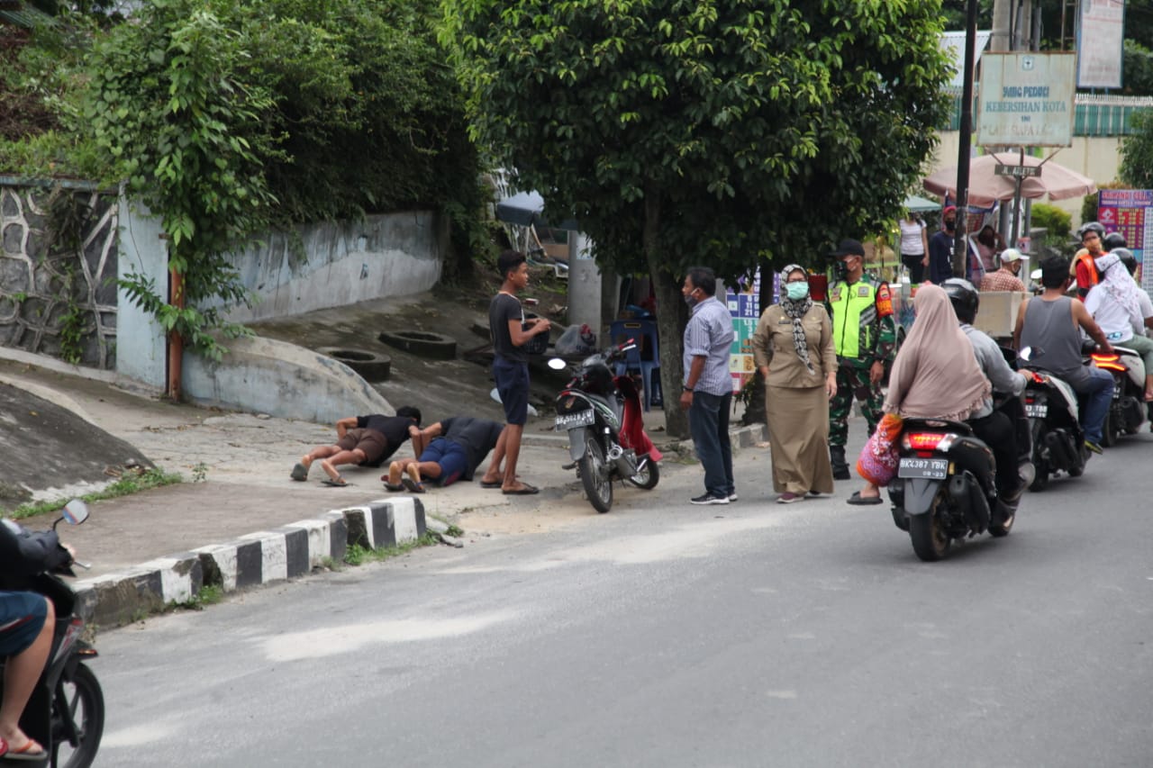 Dua warga Kota Pematangsiantar dihukum push up karena tidak memakai masker saat berada di luar rumah. 