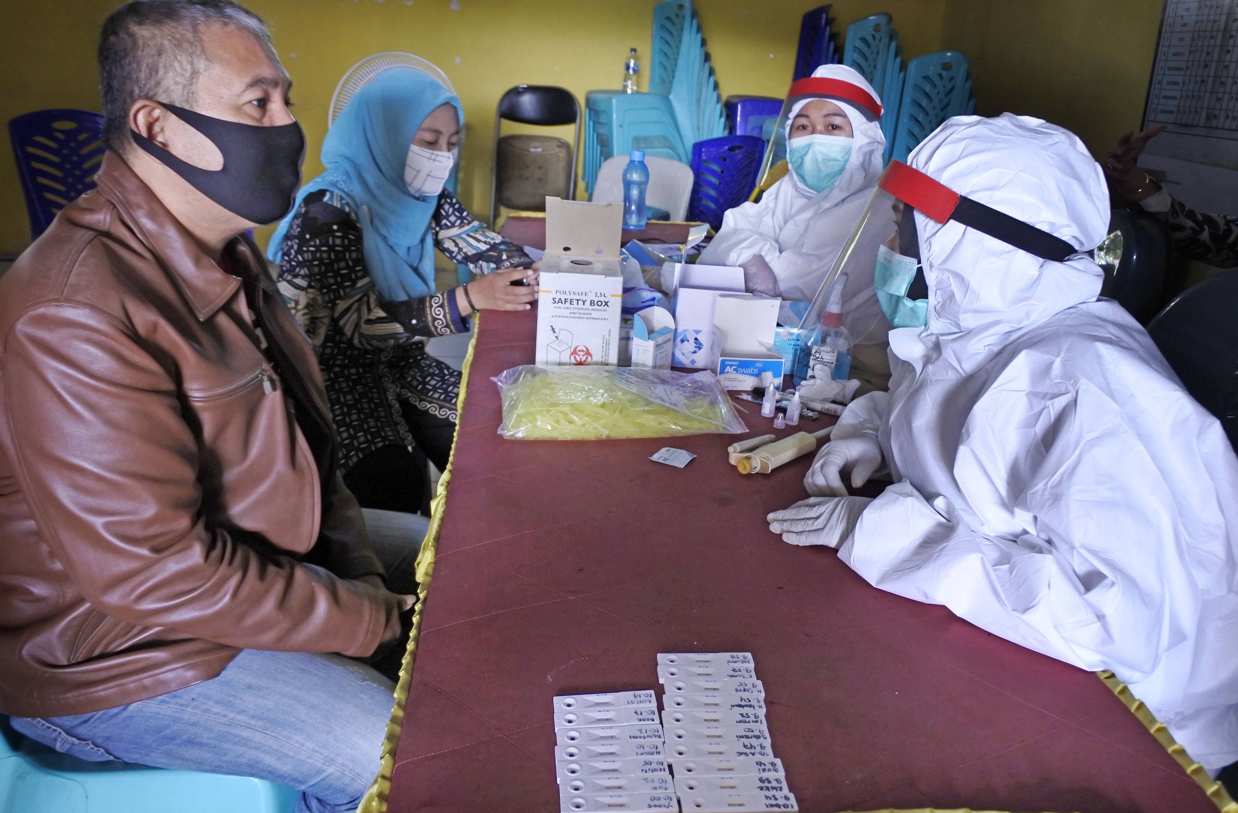 Warga berkonsultasi dengan petugas medis sebelum rapid test covid-19 di Kampung Mesjid Priyayi, Kasemen, Serang, Banten, Kamis (18/6).