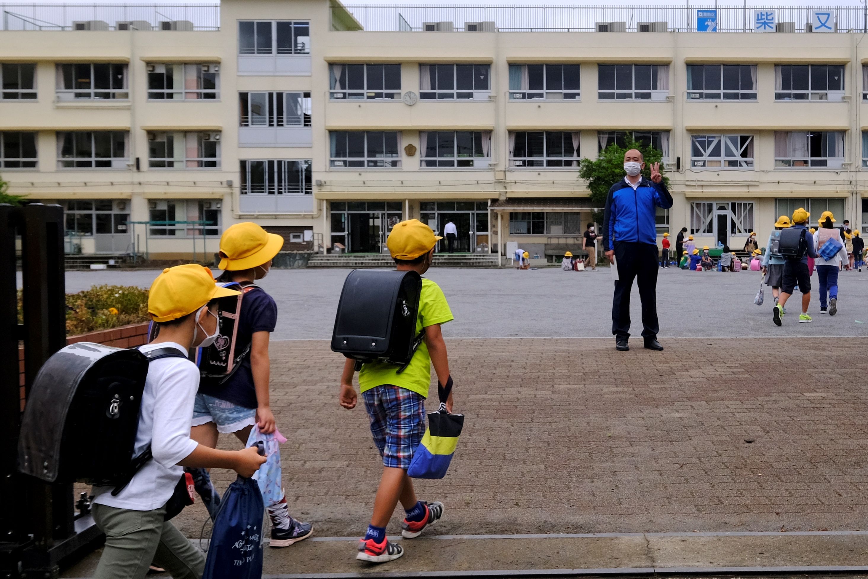 Pelajar di Jepang mulai beraktivitas normal dengan tetap mengenakan masker.
