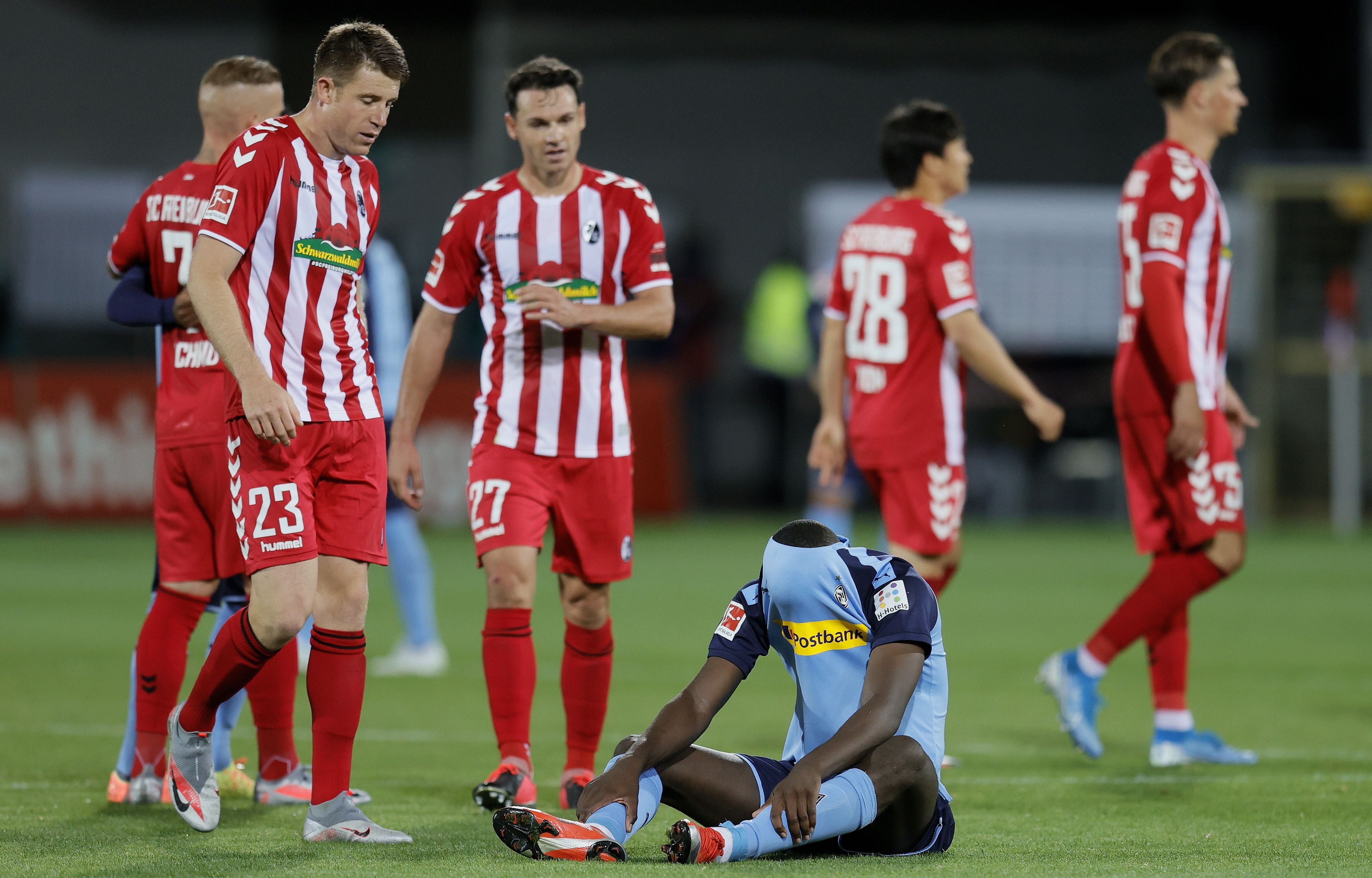 Striker Muenchengladbach Marcus Thuram (duduk) meluapkan kekecewaan usai kalah dari Freiburg dalam lanjutan uUndesliga Sabtu (6/6).