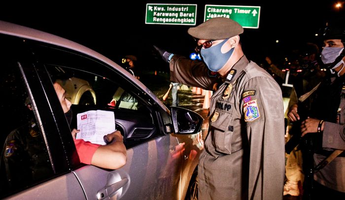 Petugas memeriksa surat tugas dan surat izin keluar masuk (SIKM) saat penyekatan arus balik Lebaran di Km 47 Tol Jakarta-Cikampek 