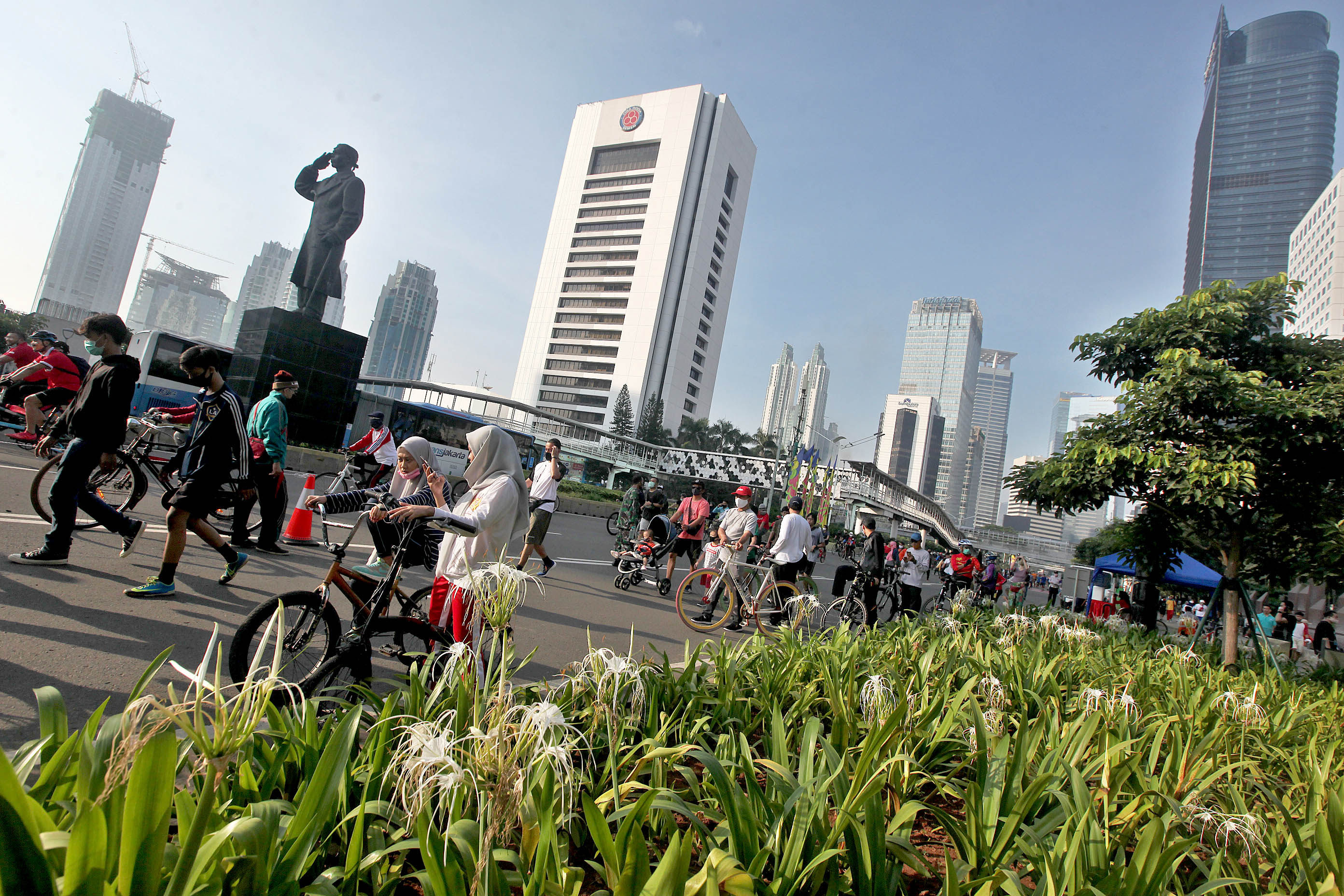 Warga berolahraga memanfaatkan dibukanya kembali hari bebas kendaraan bermotor (HBKB) masa transisi korona di kawasan Sudirman, Jakarta.
