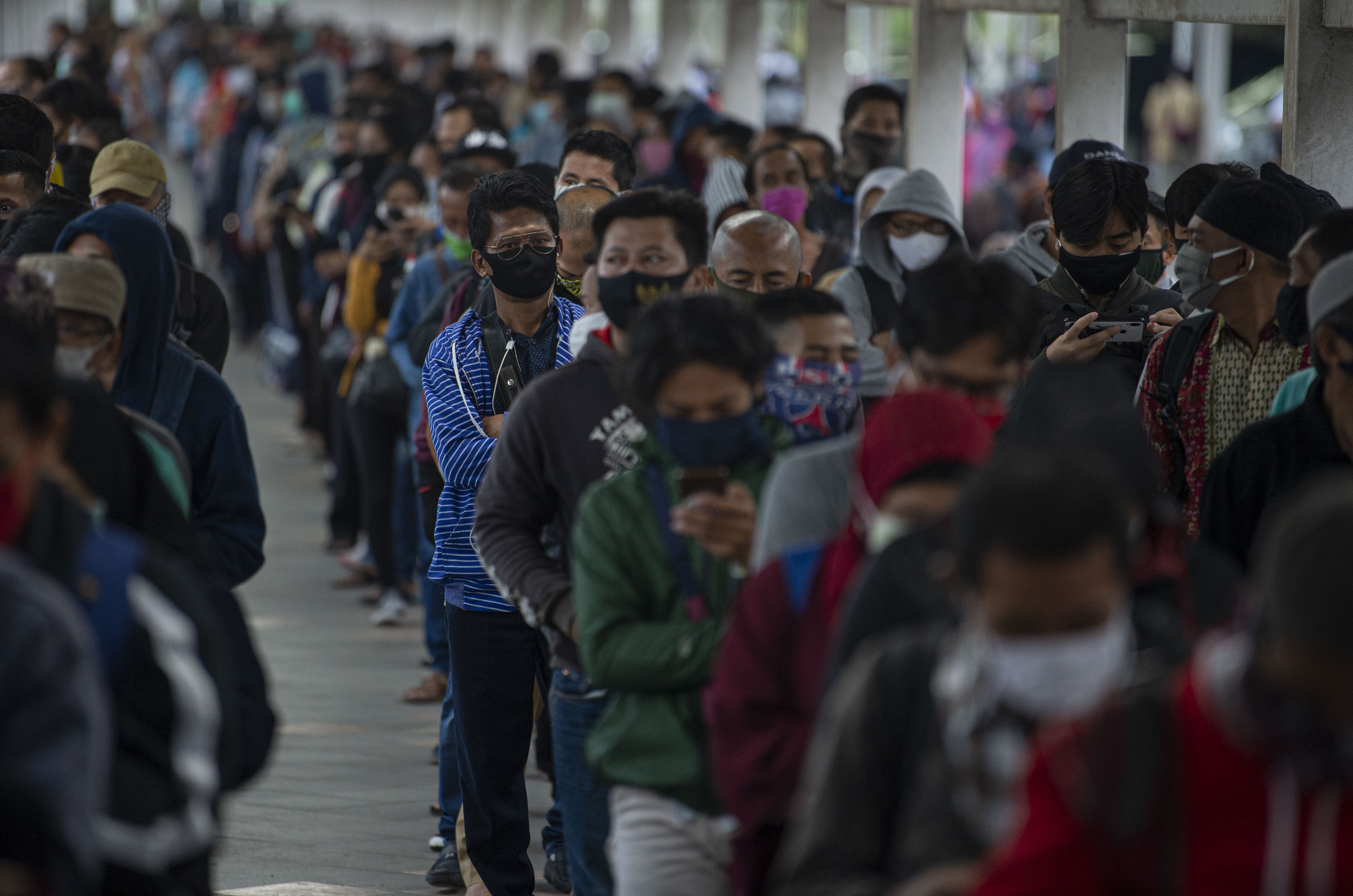 Sejumlah calon penumpang KRL Commuterline mengantre memasuki Stasiun KA Bogor di Kota Bogor, Senin (29/6/2020)
