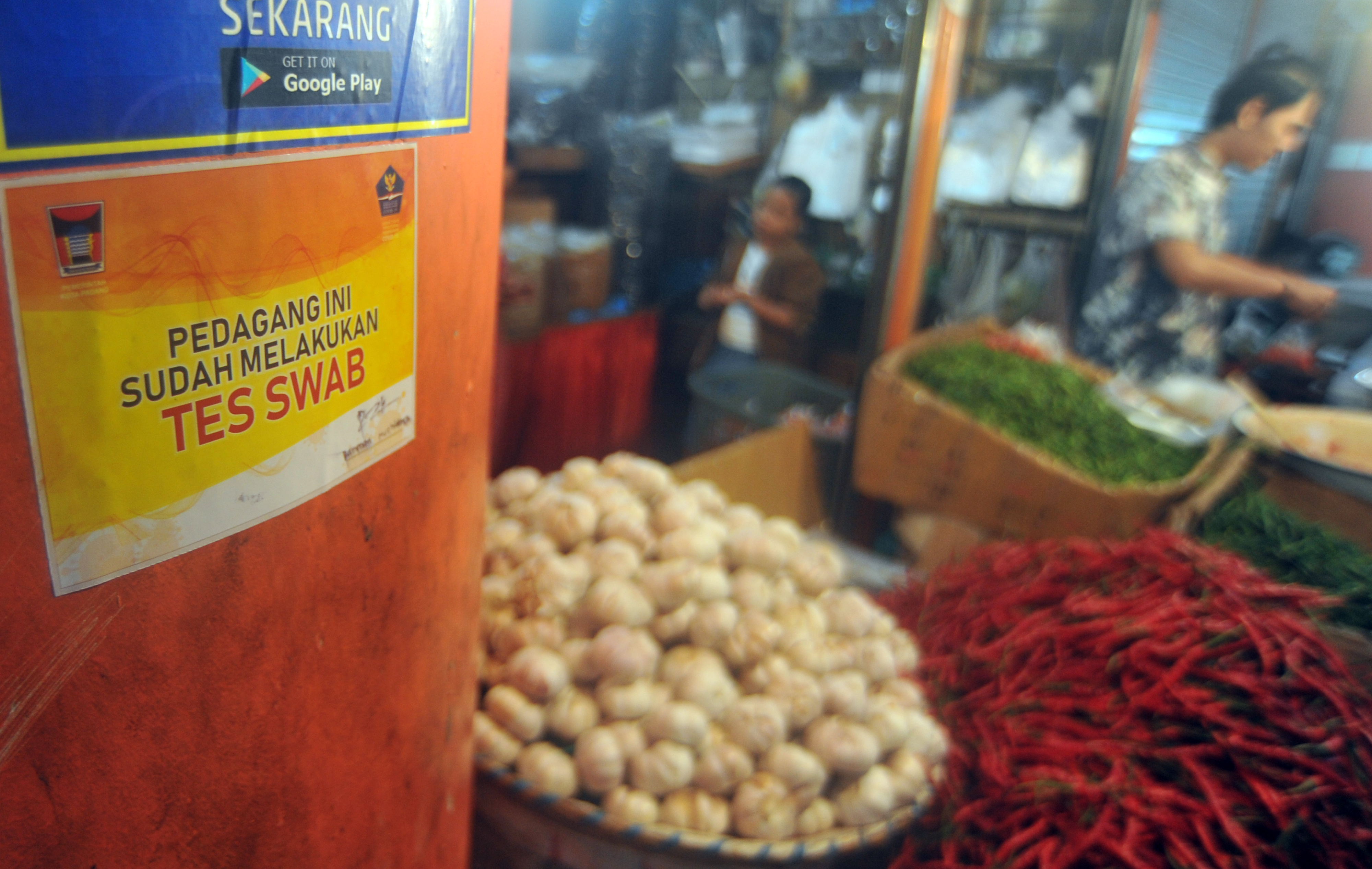 Pedagang di Pasar Raya Padang, Sumatera Barat menempelkstiker tanda sudah melakukan tes swab dan negatif COVID-19 kiosnya. 