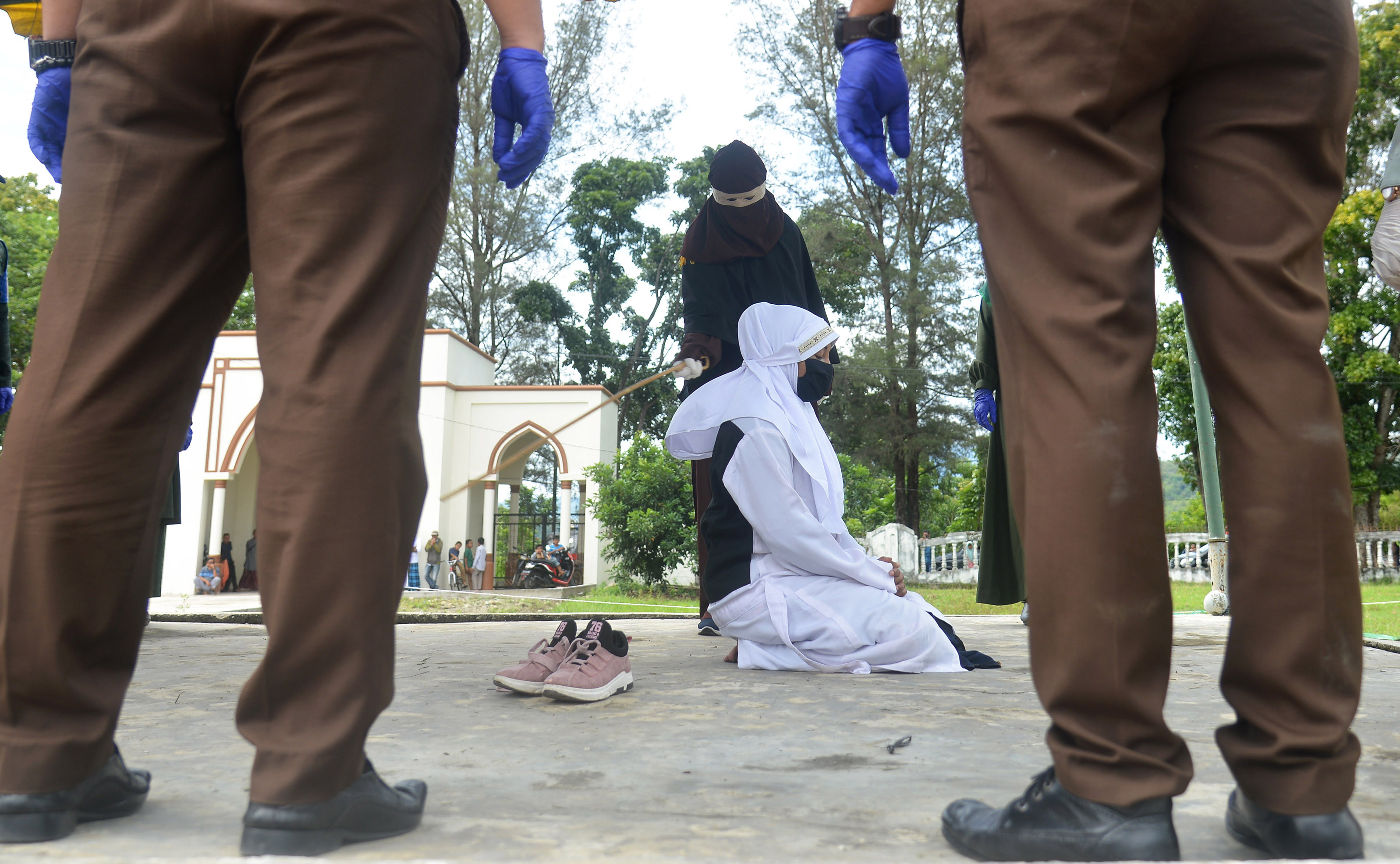 Terpidana dalam kasus zina menjalani hukuman cambuk di Masjid Al Munawarah, Kota Jantho, Kabupaten Aceh Besar, Aceh, Jumat (5/6)
