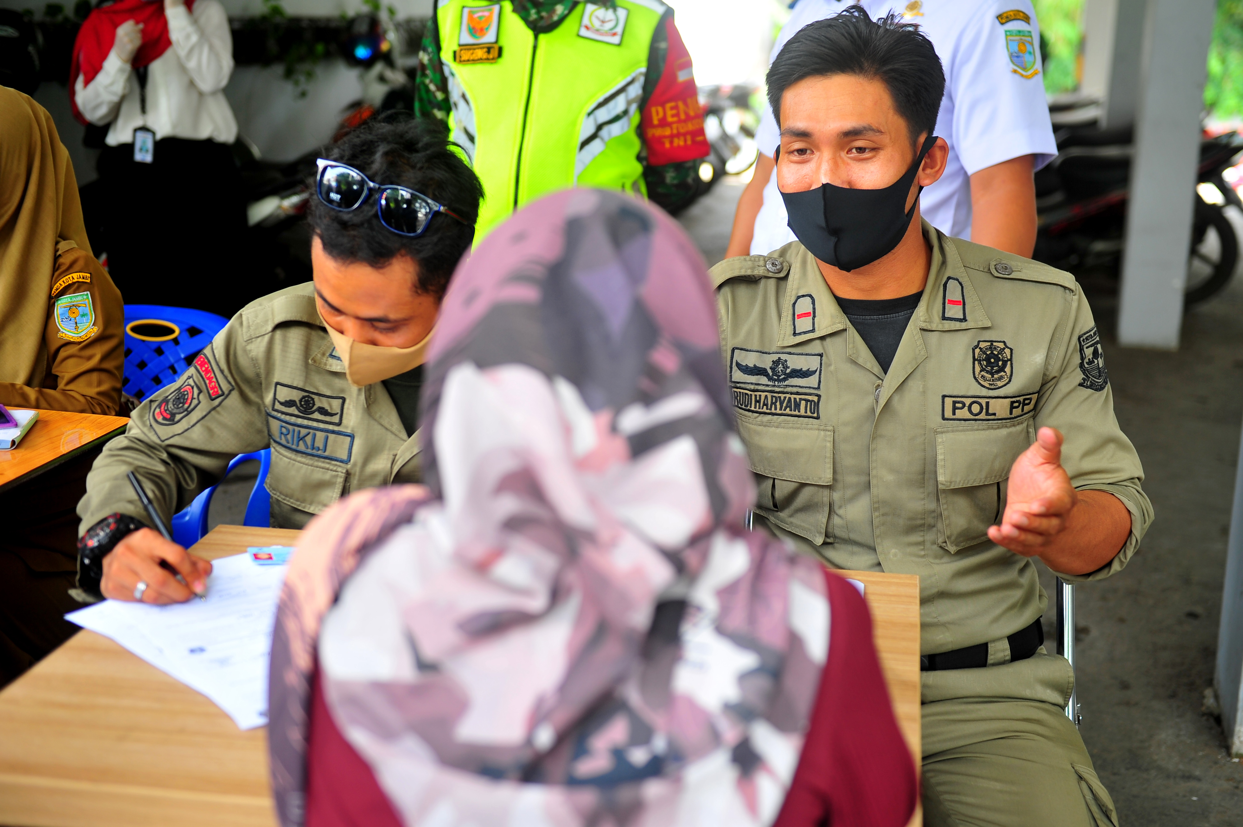 Petugas Satpol PP memberikan arahan kepada pengendara yang tidak mengenakan masker di Jambi, Senin (8/6). 