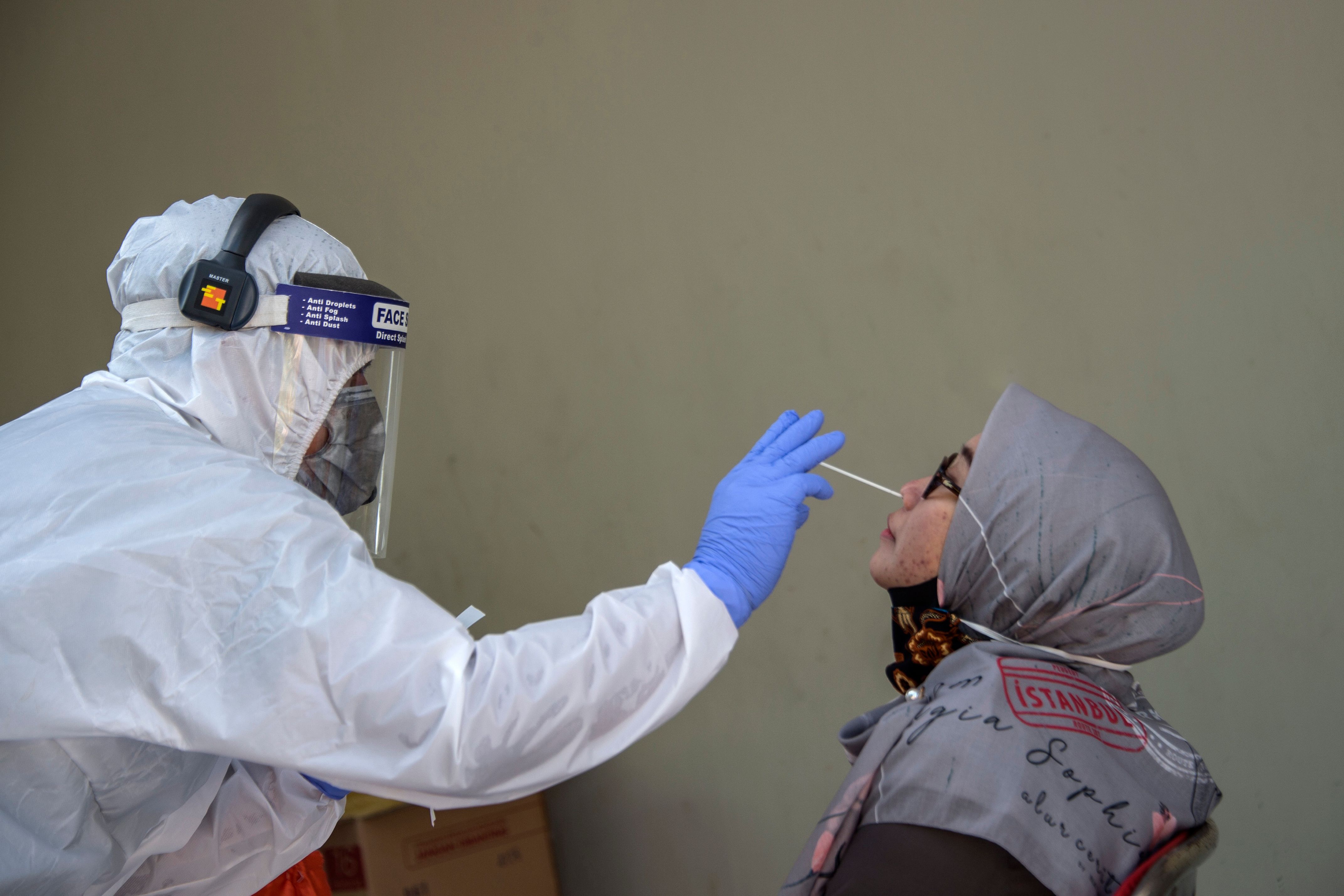 Petugas medis melakukan tes swab kepada seorang pasien untuk melihat adanya infeksi Covid-19