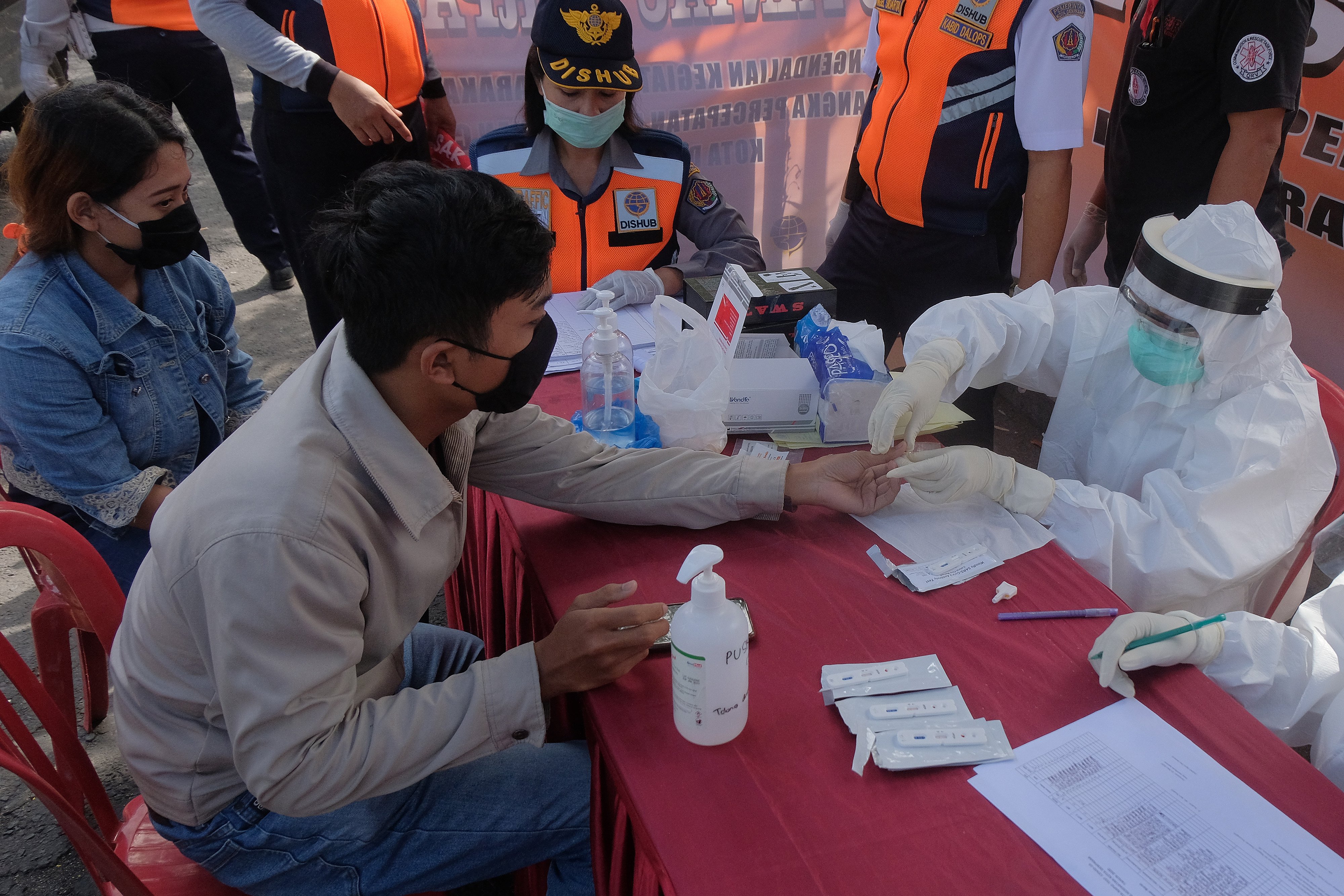 Tim medis melakukan tes cepat covid-19 dalam penerapan Pembatasan Kegiatan Masyarakat (PKM) di pos pantau perbatasan Penatih, Bali