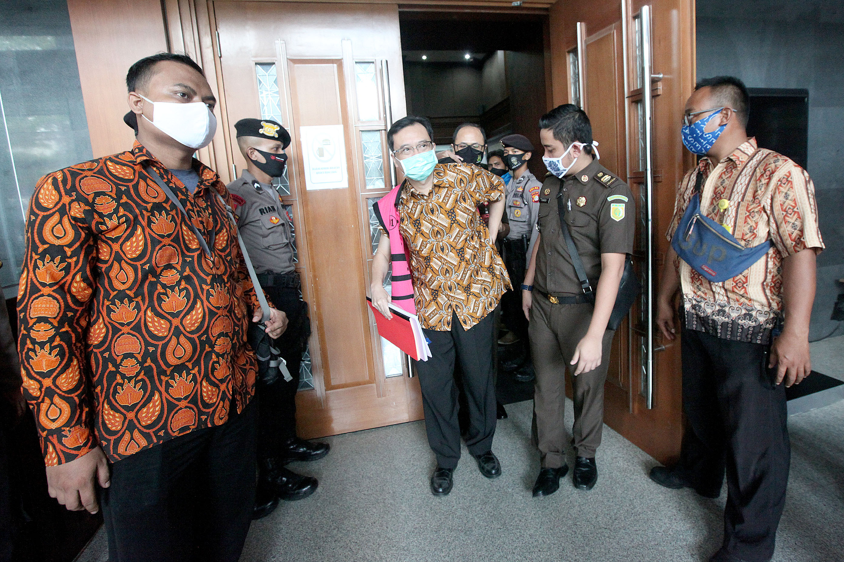 Terdakwa Direktur PT Hanson Internasional Benny Tjokrosaputro berjalan keluar mengenakan rompi merah jambu seusai menjalani persidangan.