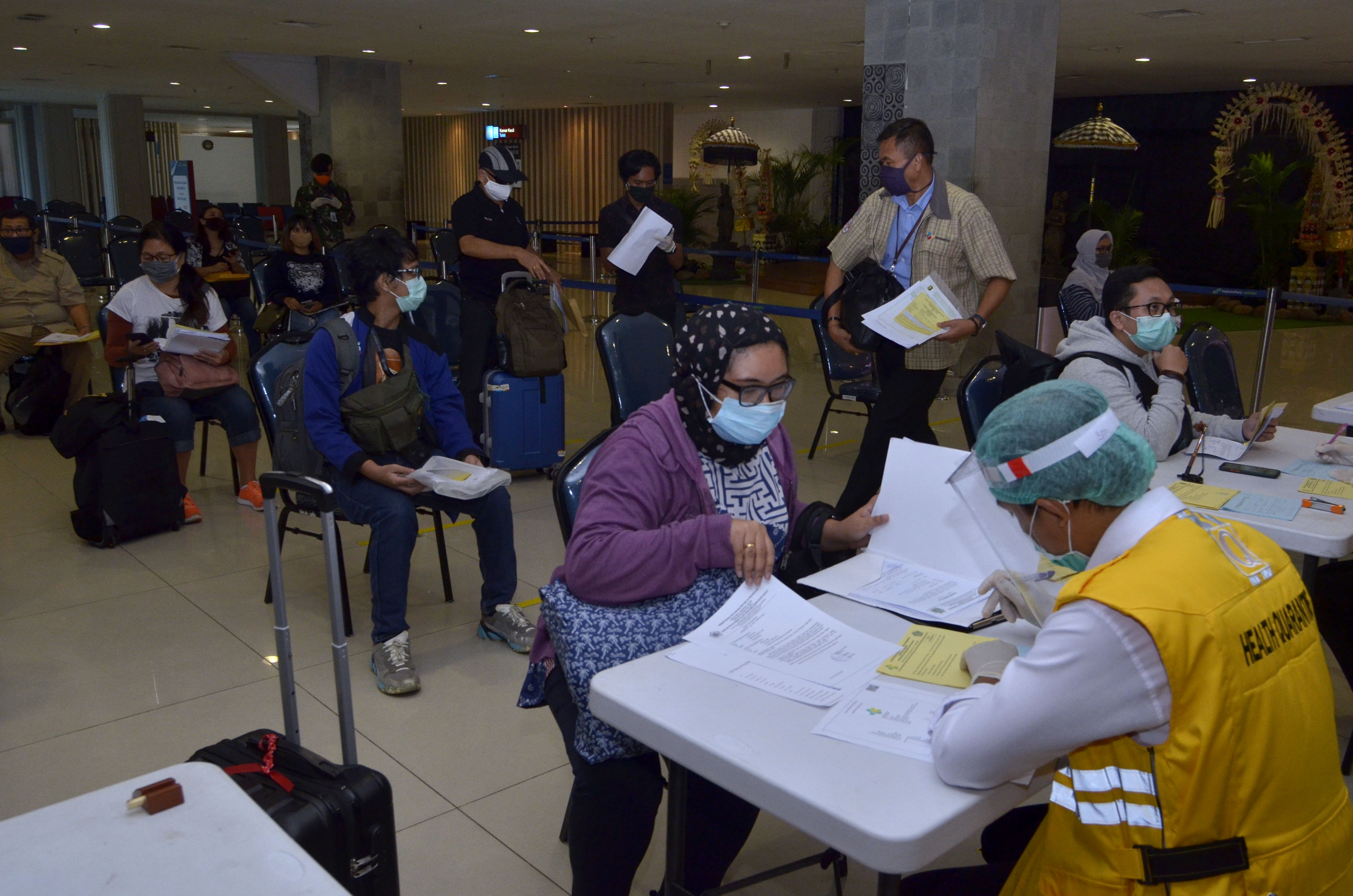 Petugas melakukan pemeriksaan dokumen perjalanan penumpang pesawat yang tiba di Terminal Domestik Bandara Internasional I Gusti Ngurah Rai, 