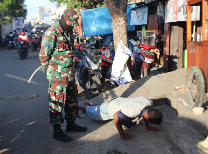 Aparat TNI menghukum pengunjung Pasar TPI Kabupaten Sikka, NTT dengan push up 50 kali karena tidak memakai masker, Kamis (18/6/2020)