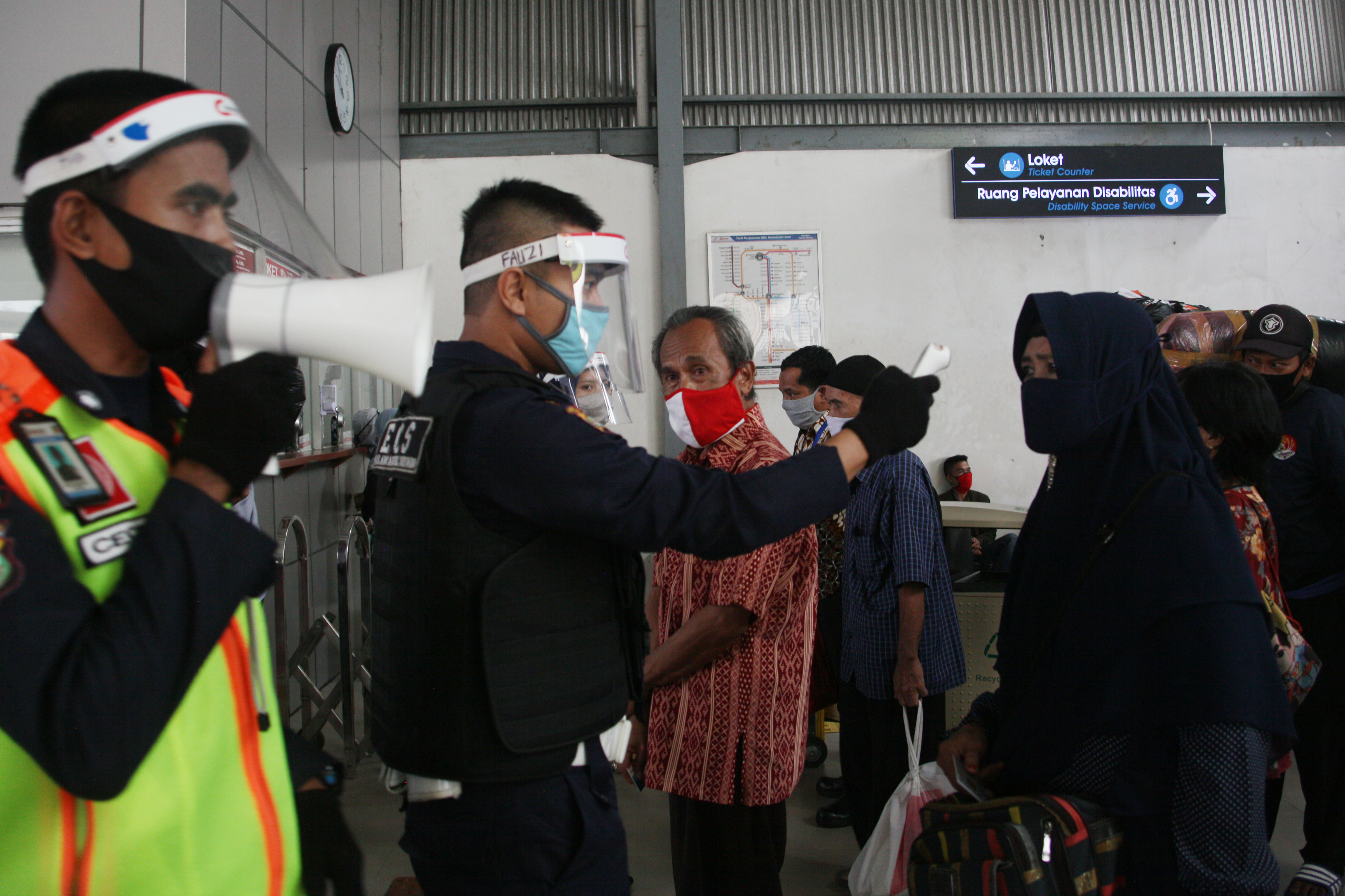 Sebelum naik KRL, penumpang dicek suhunya.