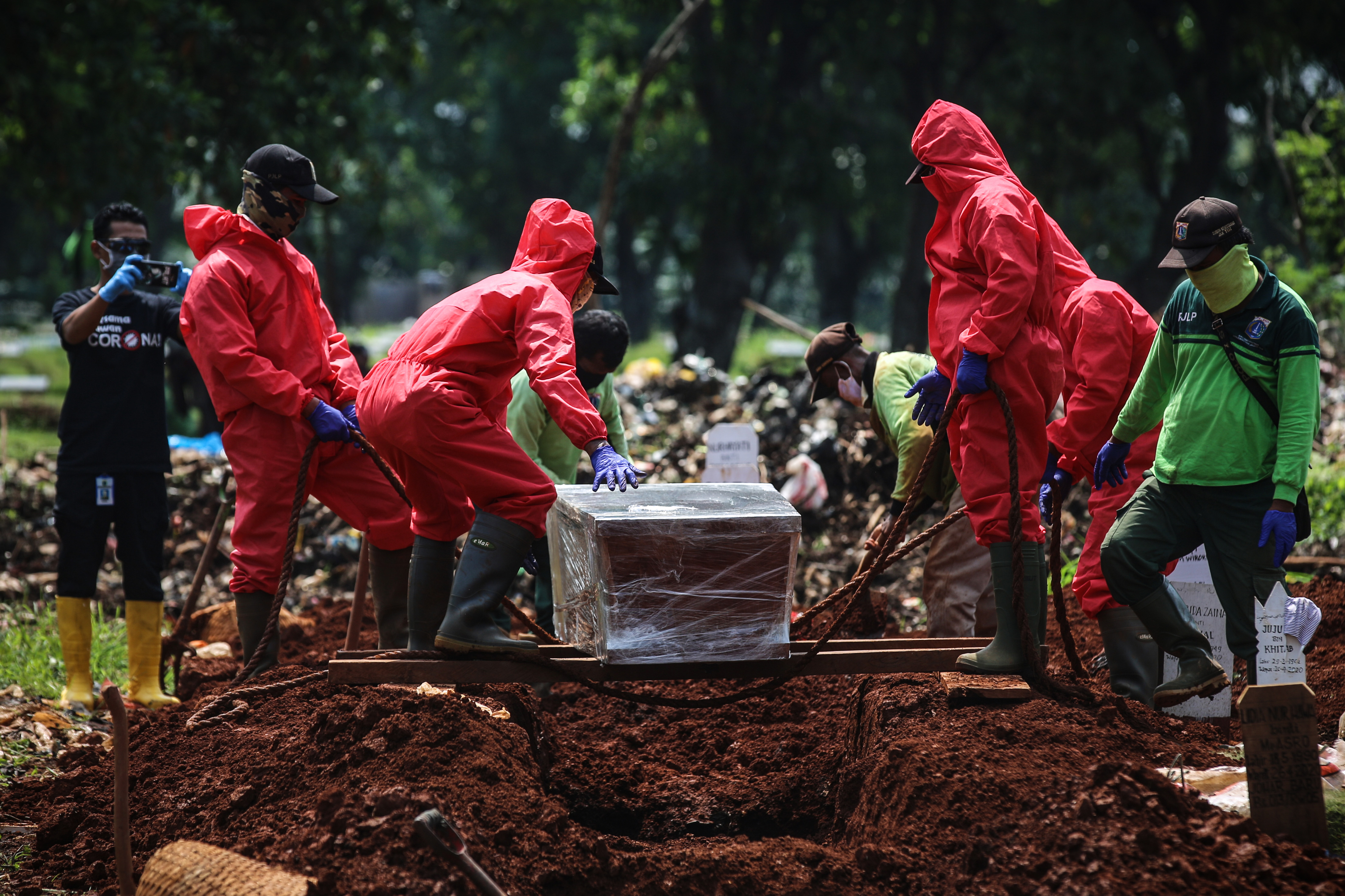 Petugas pemakaman memakamkan jenazah covid-19 sesuai protokol di TPU Pondok Ranggon, Jakarta, 7/5/2020
