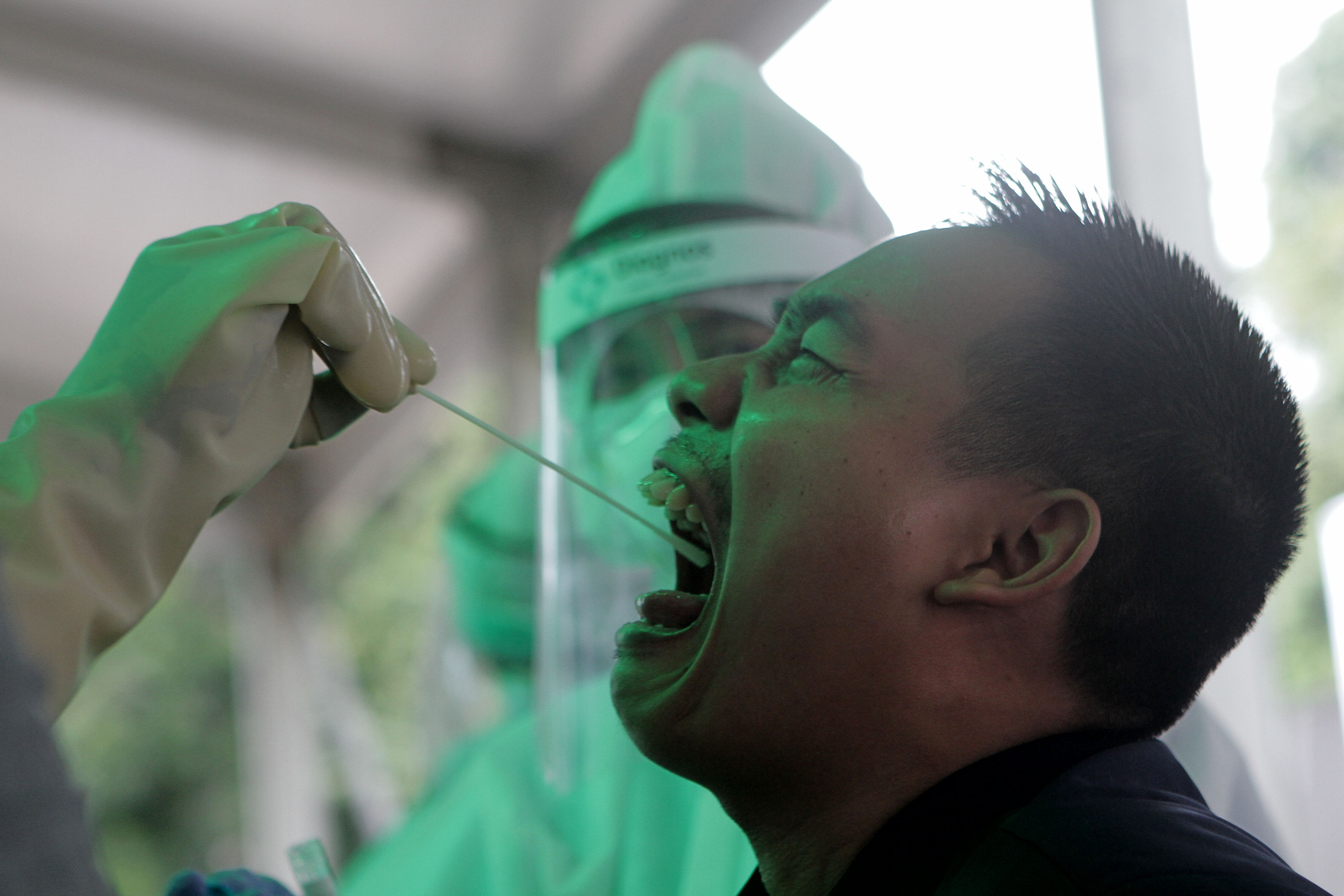 Tenaga medis melakukan swab test gratis untuk warga di parkiran selatan, komplek Stadion Utama Gelora Bung Karno, Jakarta, 20 Mei 2020.