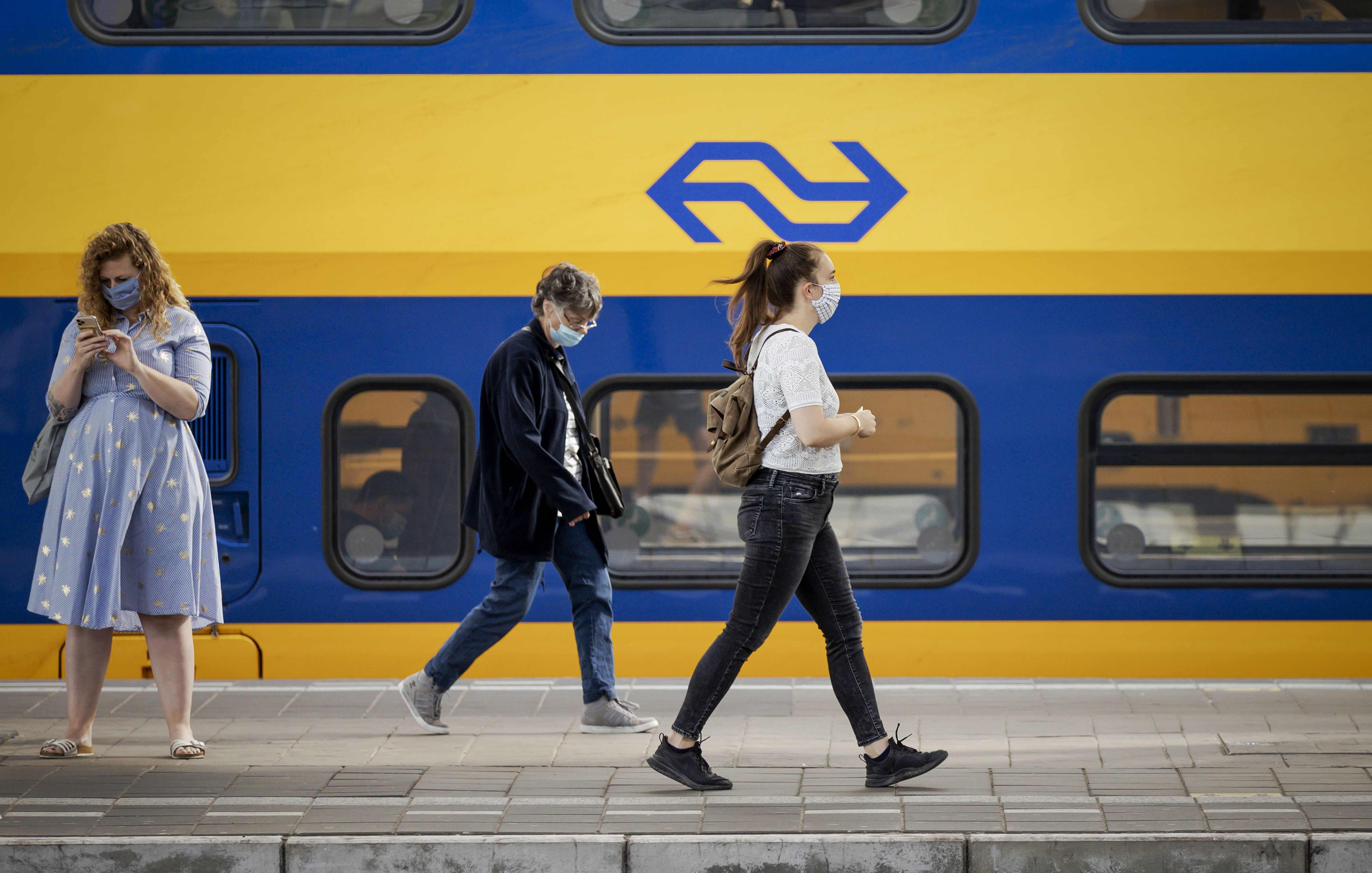 Warga mengenakan masker di stasiun kereta Amsterdam, Belanda