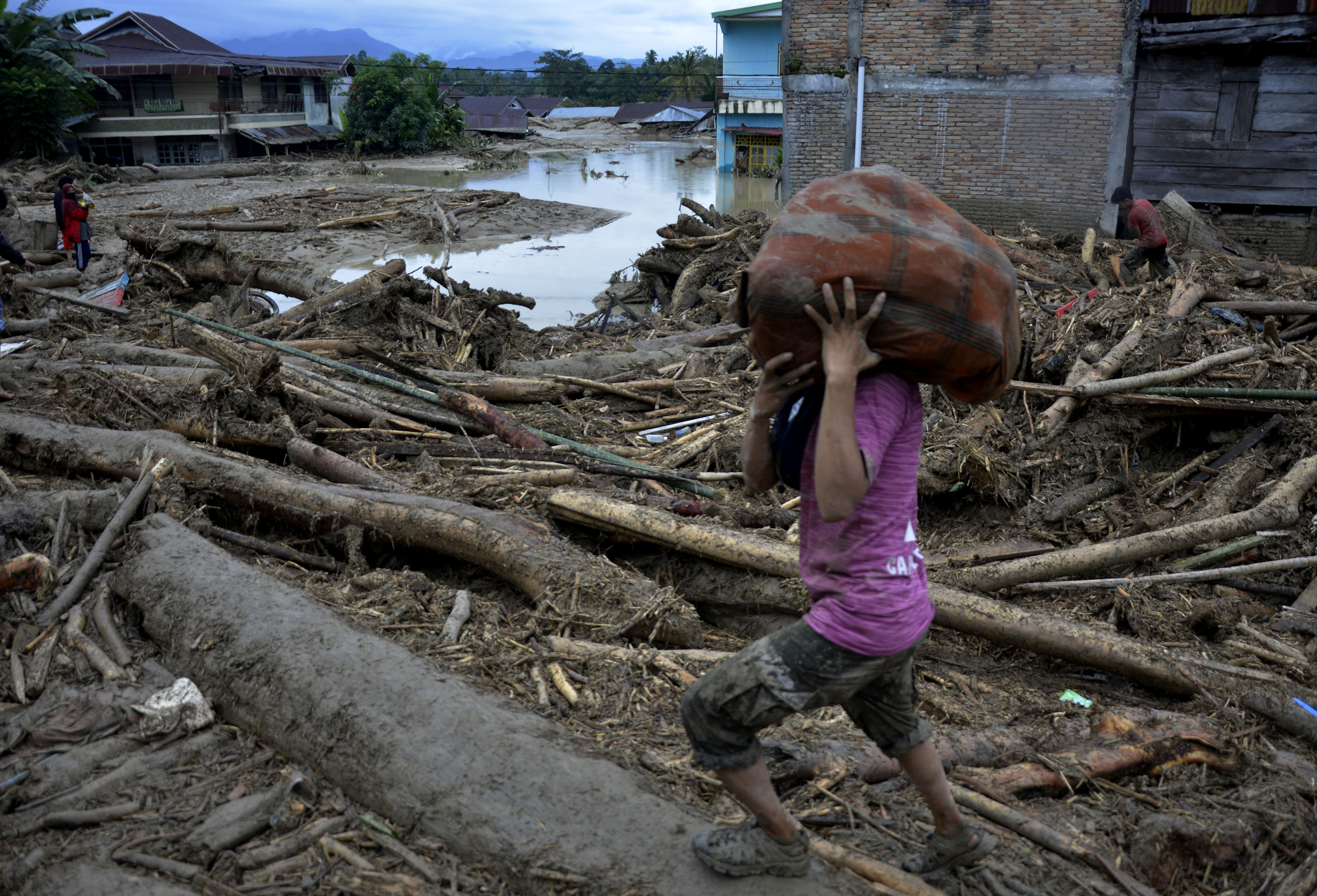 Waga menyelamatkan hartanya akibat banjir bandang di Kecamatan Masammba, Kabupaten Luwu Utara, Sulawesi Selatan, Rabu (15/7/2020).