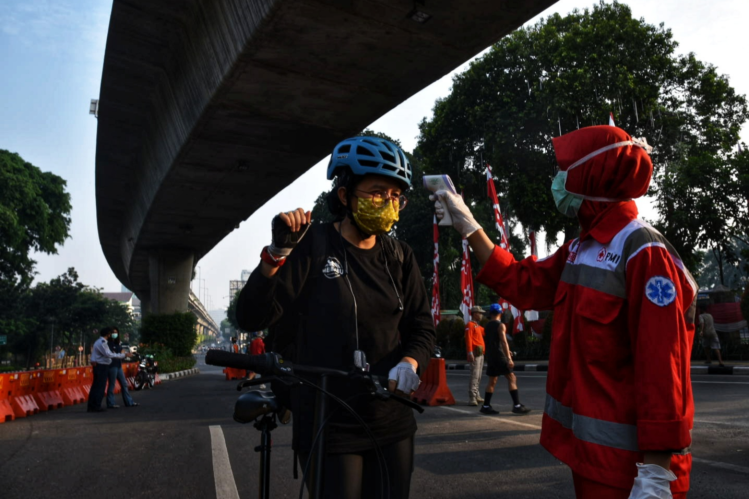 Petugas memeriksa suhu tubuh pesepeda di Jalan Layang Non Tol (JLNT) Antasari-Blok M, Jakarta
