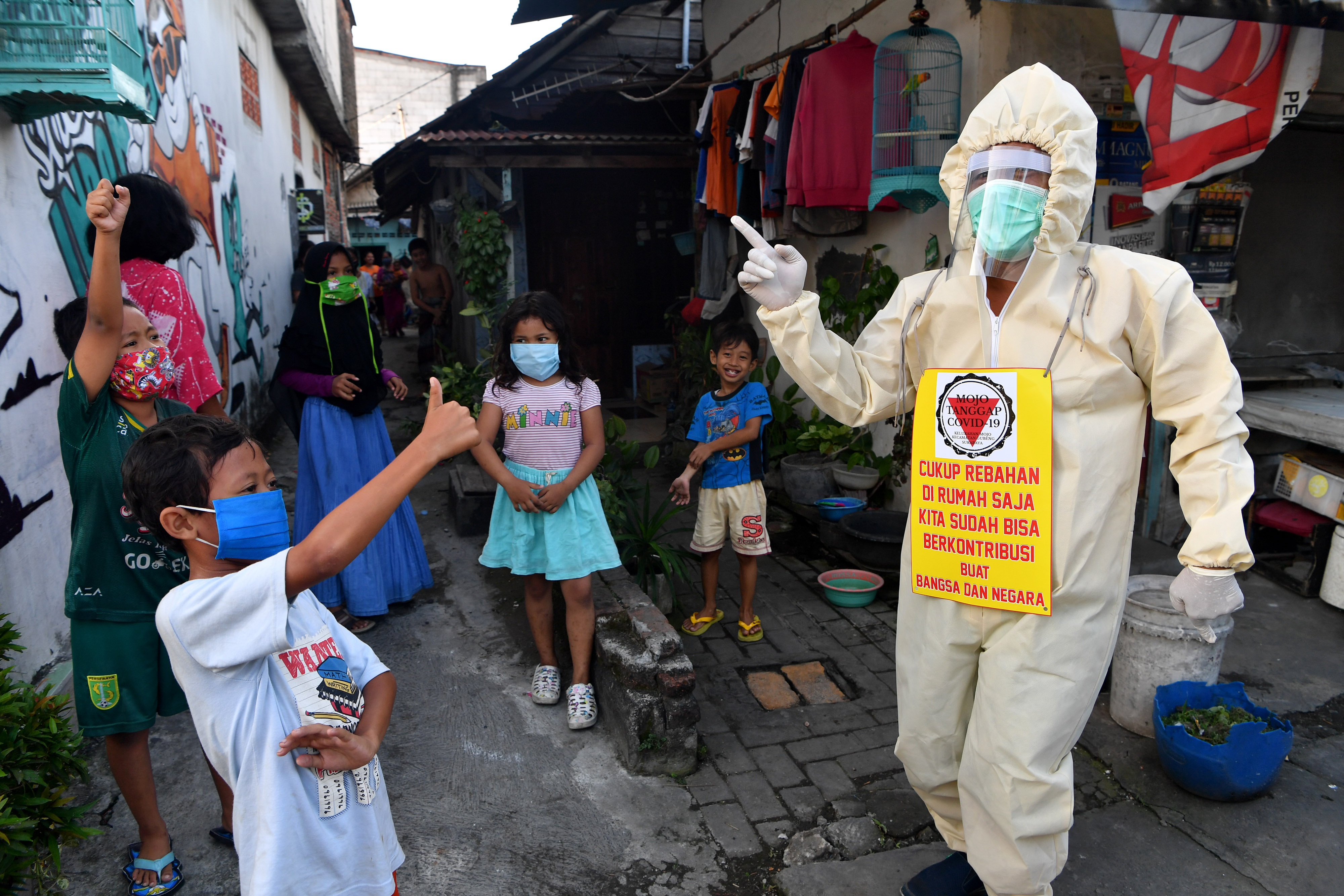 Seorang warga melakukan sosialiasi pencegahan covid-19 di Surabaya, Jawa Timur.