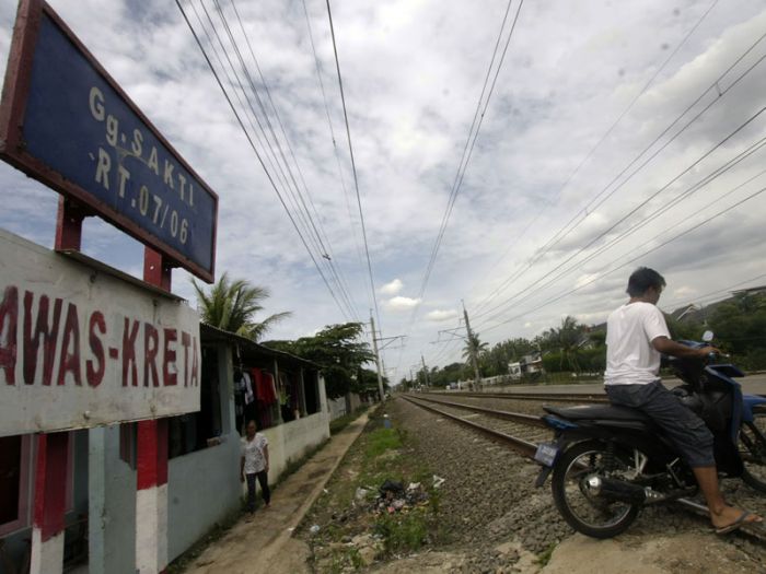 Warga tengah melintas di dekat perlintasan kereta api Stasiun Citayam, Kota Depok.