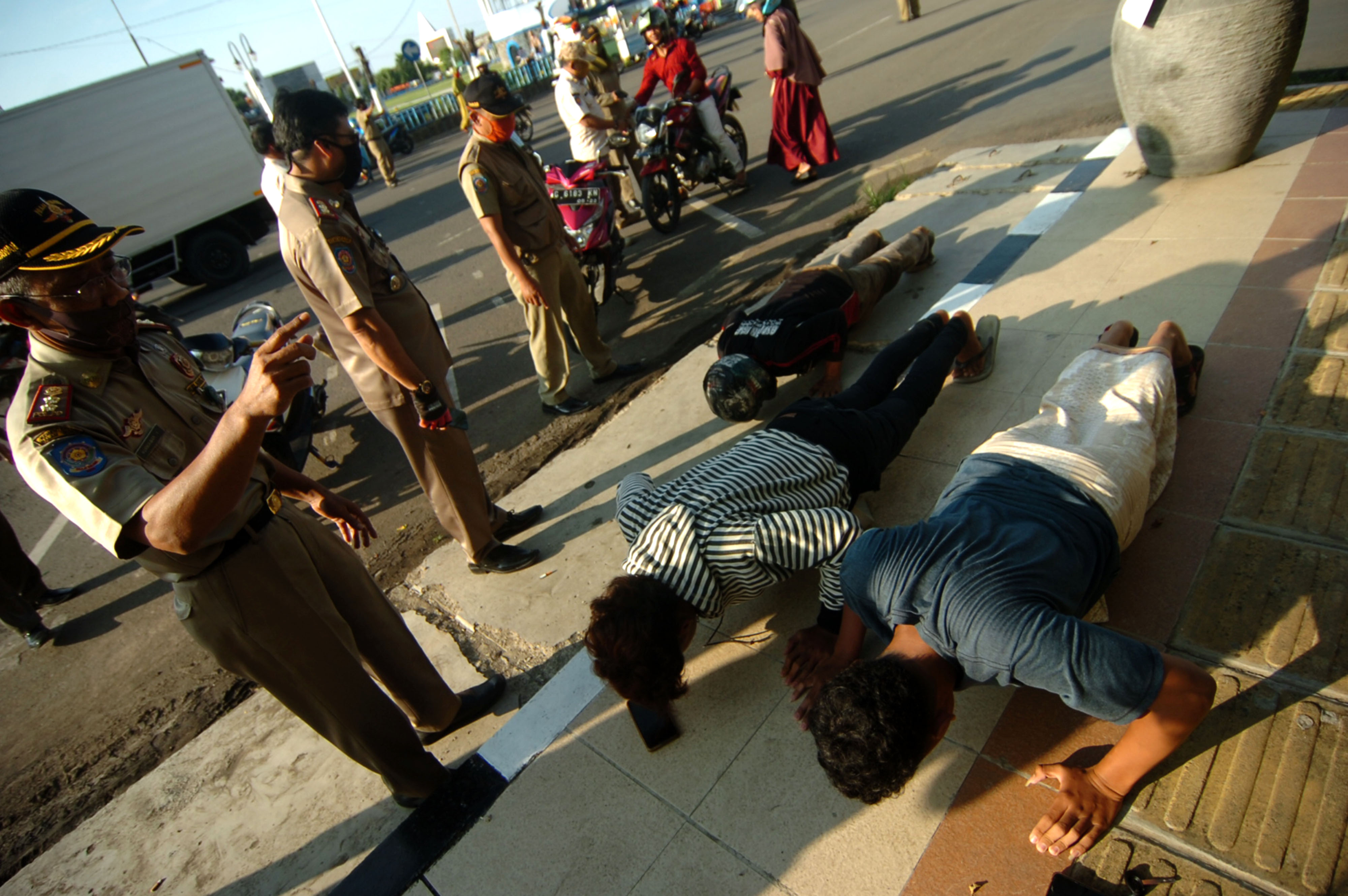 Warga terkena sanksi push up karena tidak mengenakan masker di Alun-alun Kota Tegal, Jawa Tengah, Selasa (2/6/2020). 