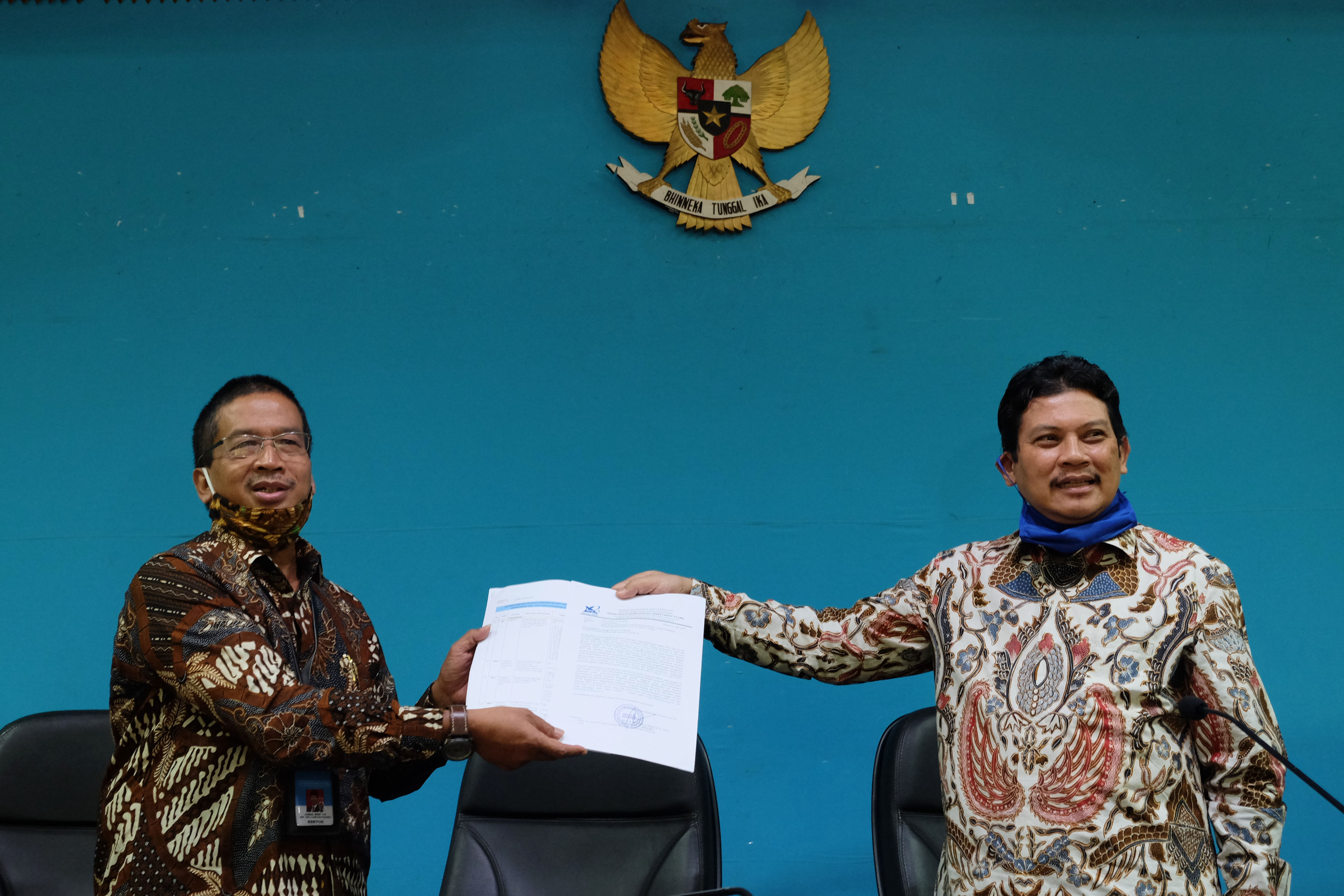 KETUA Konsorsium Riset dan Inovasi COVID-19 Kemenristek/BRIN Ali Ghufron Mukti (kanan) menyerahkan laporan dukungan pendanaan