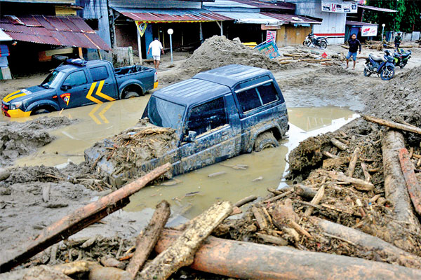 Sejumlah kendaraan dan rumah warga yang tertimbun lumpur setelah diterjang banjir bandang di Kecamatan Masammba, Kabupaten Luwu Utara