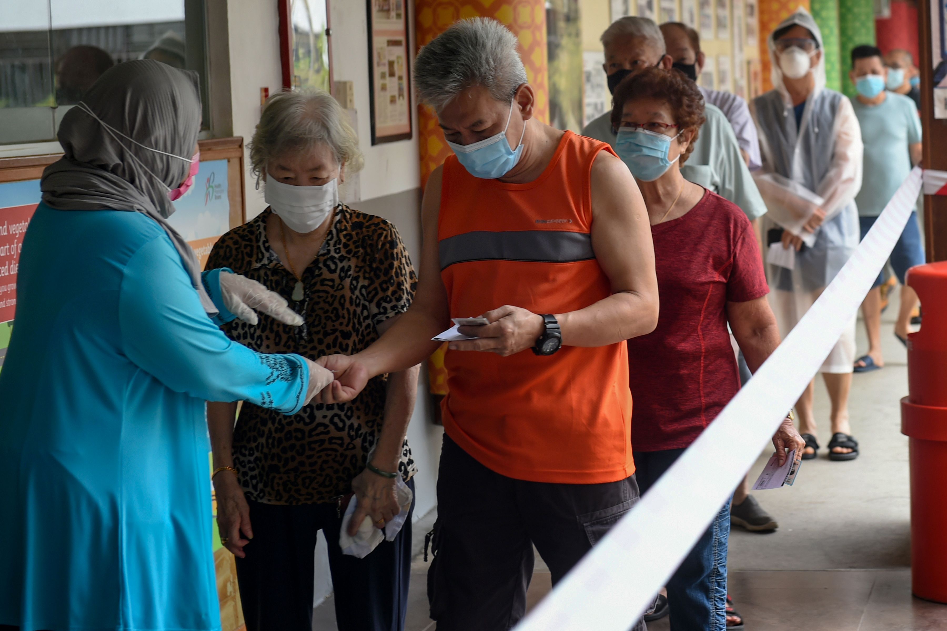 Warga Singapura mengantri untuk mencoblos dengan pemberlakuan protokol kesehatan.