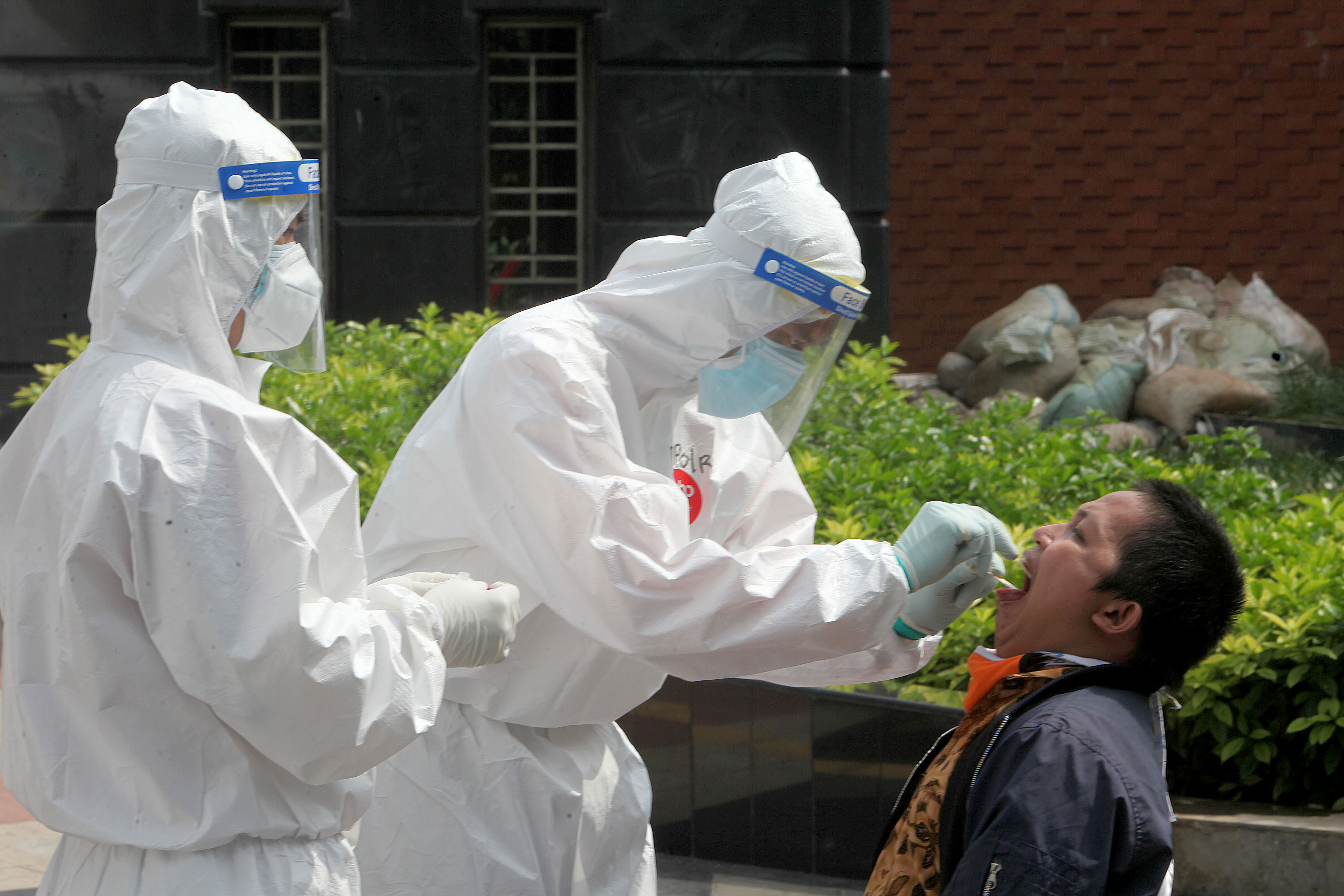 Petugas kesehatan melakukan swab test kepada warga yang hasil rapid test covid-19 reaktif.