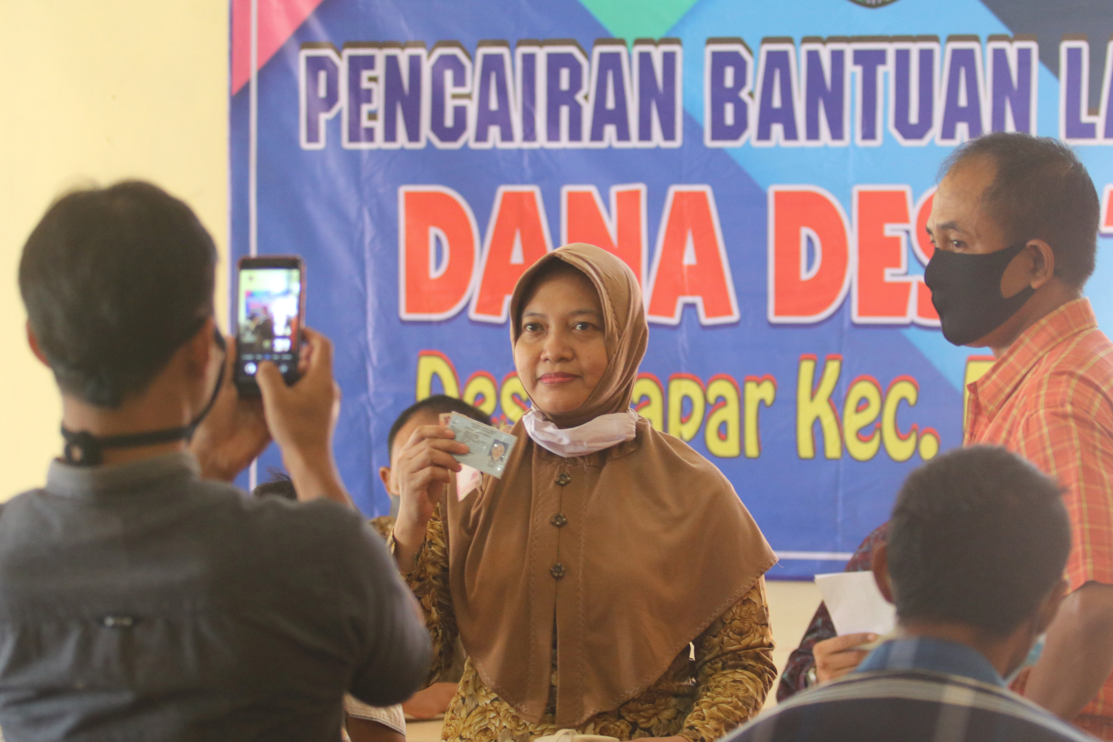 Seorang warga memperlihatkan bukti pengambilan BLT Dana Desa di Kediri, Jawa Timur.