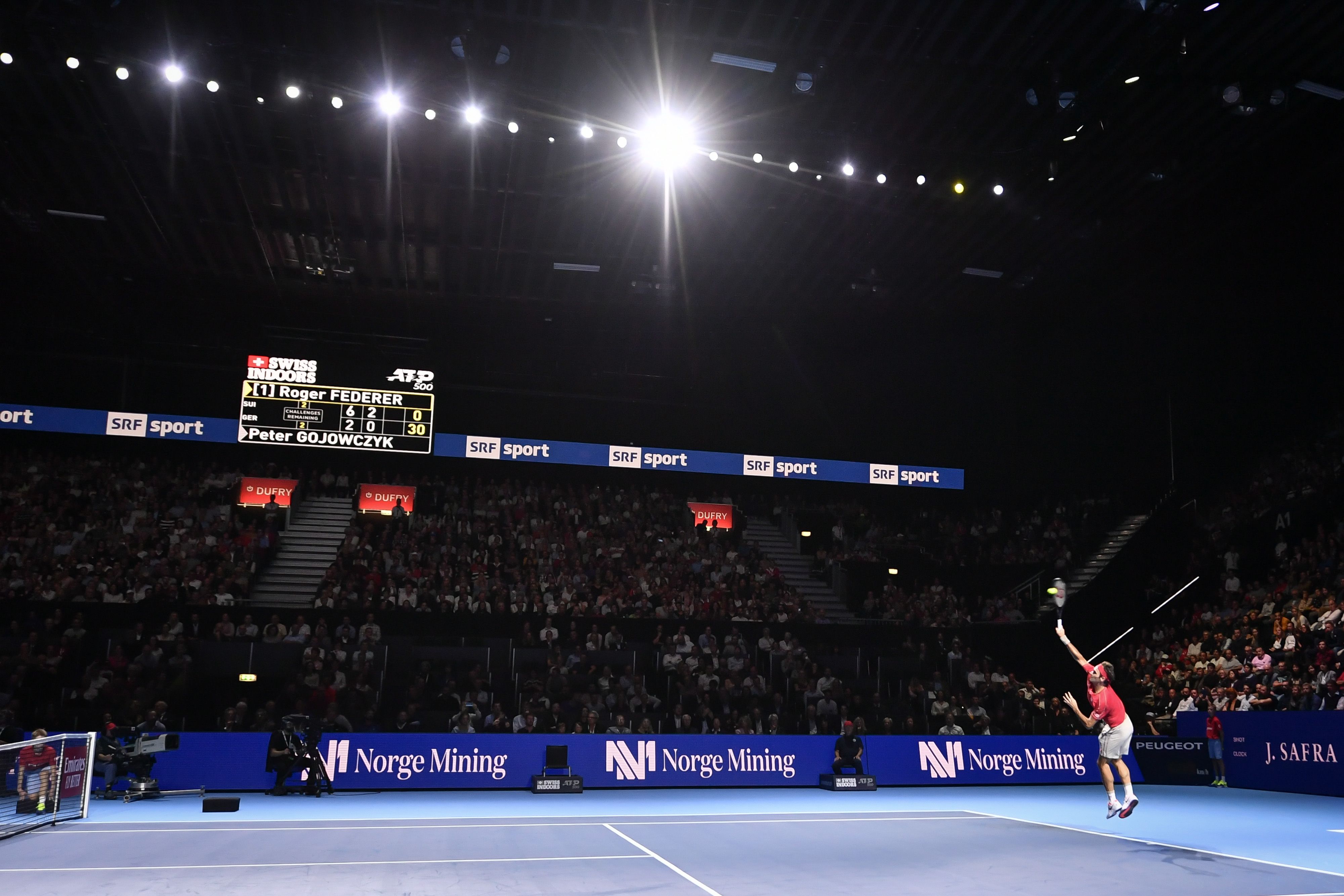 Roger Federer melepaskan servis saat tampil di Swiss Indoor 2019.