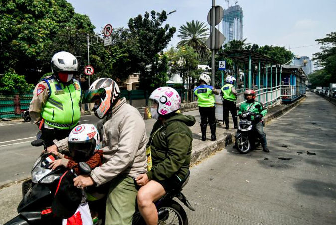 Polisi Lalu lintas memberhentikan sejumlah kendaraan yang kedapatan menerobos jalur Trans-Jakarta di Jalan Galunggung, Setiabudi.  