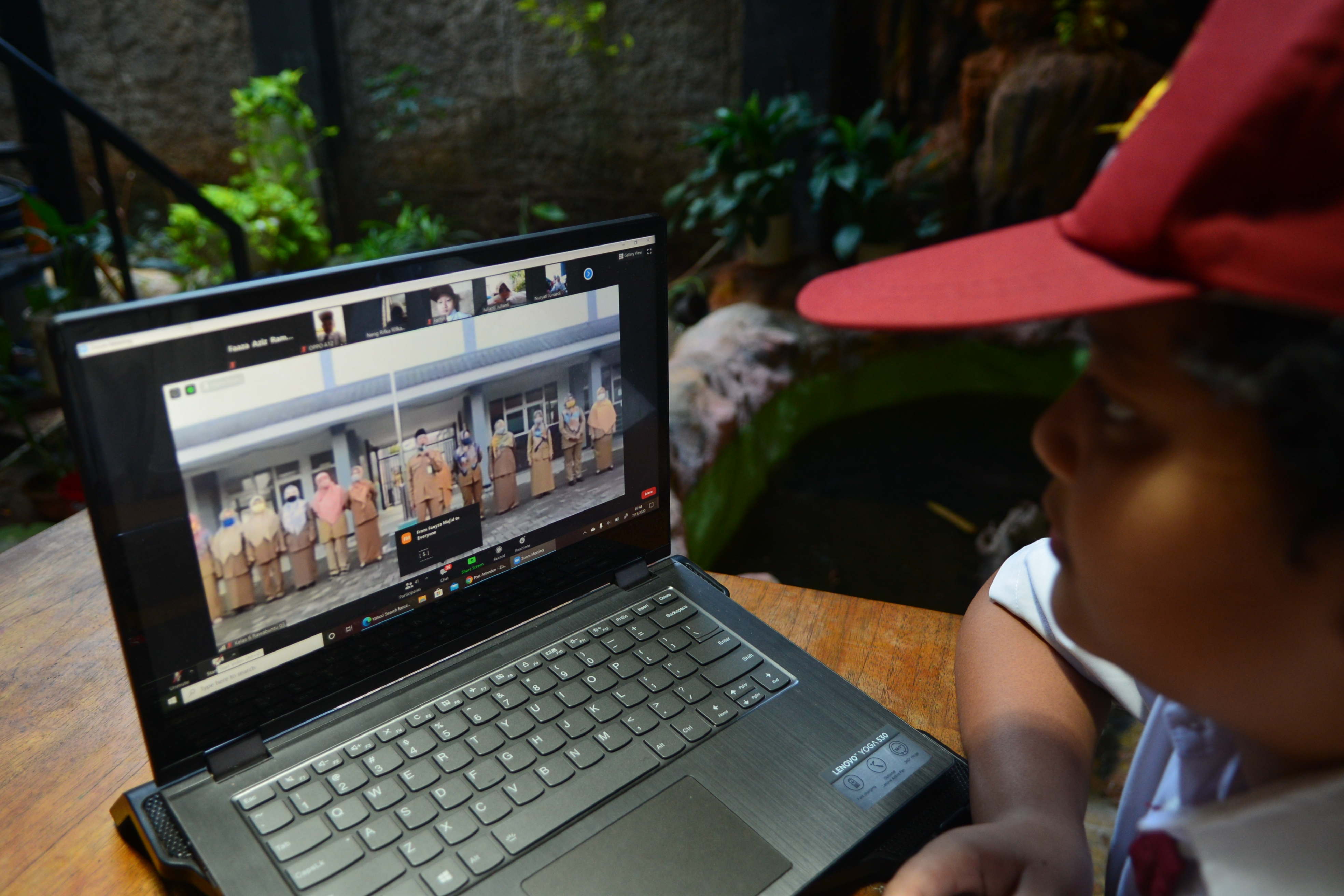 Murid sekolah melakukan upcara virtual di hari pertama tahun ajaran baru 