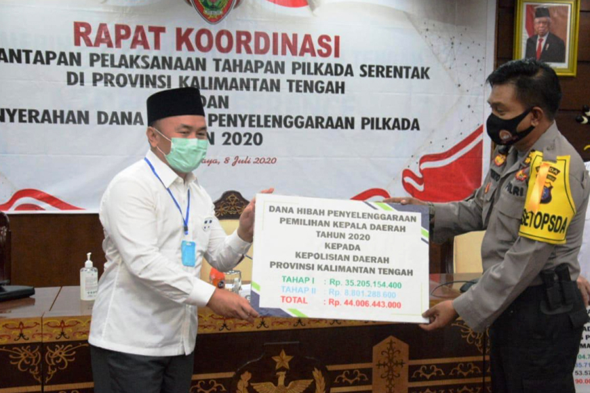 Gubernur Kalteng Sugianto Sabran (kiri) menyerahkan dana hibah Pilkada Serentak 2020 kepada Polda Kalteng.