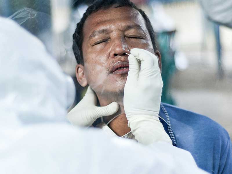 Tim medis Puskesmas Kecamatan Sawah Besar mengambil sampel lendir warga saat tes swab 